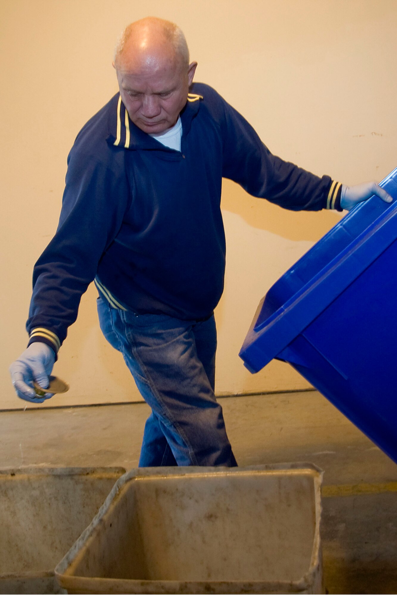 GRISSOM AIR RESERVE BASE, Ind. -- Dan Miller, 434th Civil Engineer Squadron general services and support worker, throws a metal can lid meant for recycling into a bin as he sorts through recyclable materials on base May 2. In 2010, the base recycled more than 174 tons of material including 91 tons of scrap metal, 48 tons of cardboard, 29 tons of paper and 2 tons of used tires. The recycling program alone netted almost $23,000 last year, which is used to buy new equipment, supplies and promotional items. (U.S. Air Force photo/Tech. Sgt. Mark R. W. Orders-Woempner)
