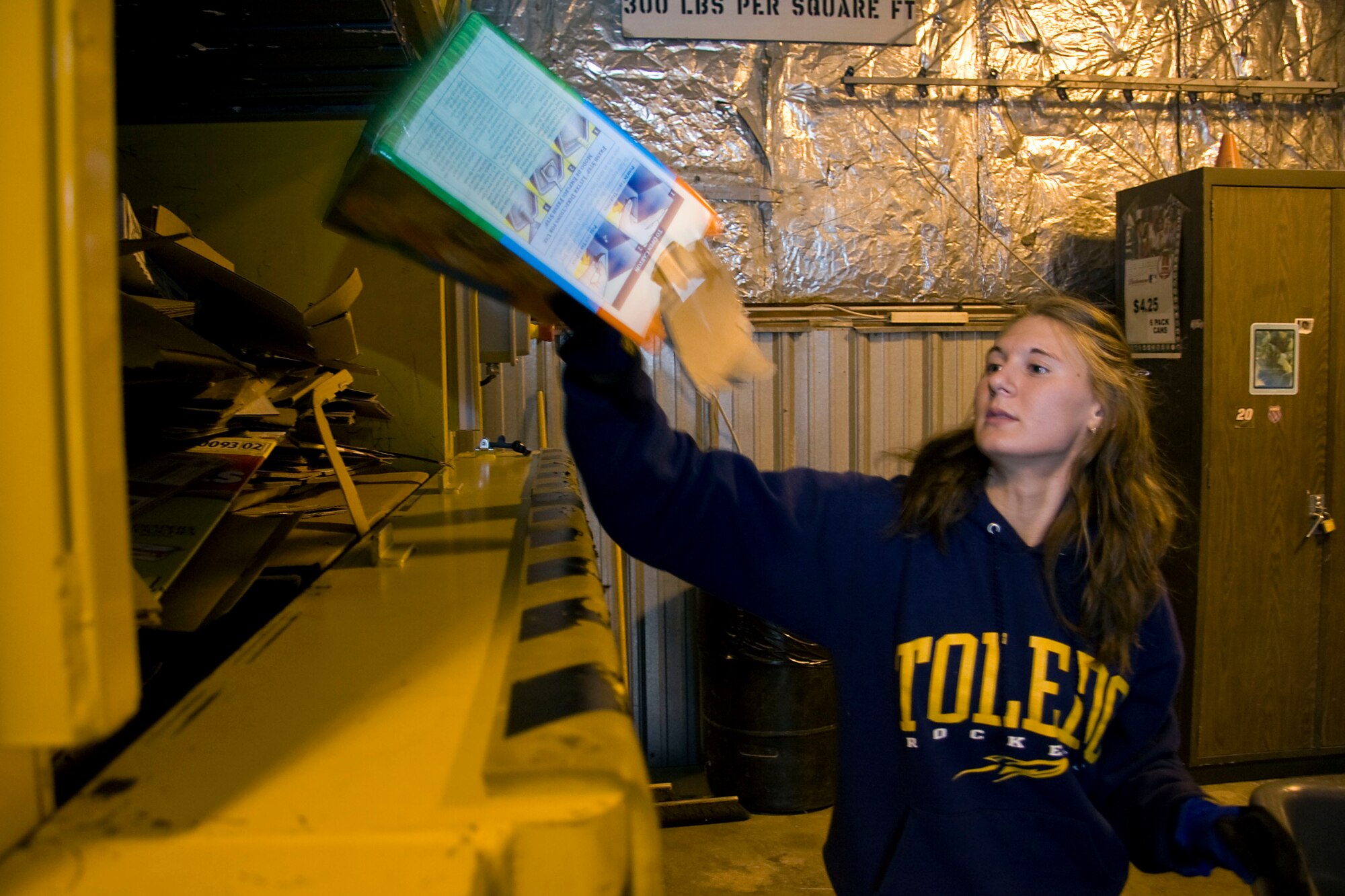 GRISSOM AIR RESERVE BASE, Ind. -- Lisa Maynard, 434th Civil Engineer Squadron laborer, throws cardboard into a compactor May 2, where it will be crushed, baled and shipped away for recycling. In 2010, the base recycled over 174 tons of material including 91 tons of scrap metal, 48 tons of cardboard, 29 tons of paper and 2 tons of used tires. The recycling program alone netted almost $23,000 last year, which is used to buy new equipment, supplies and promotional items. (U.S. Air Force photo/Tech. Sgt. Mark R. W. Orders-Woempner)
