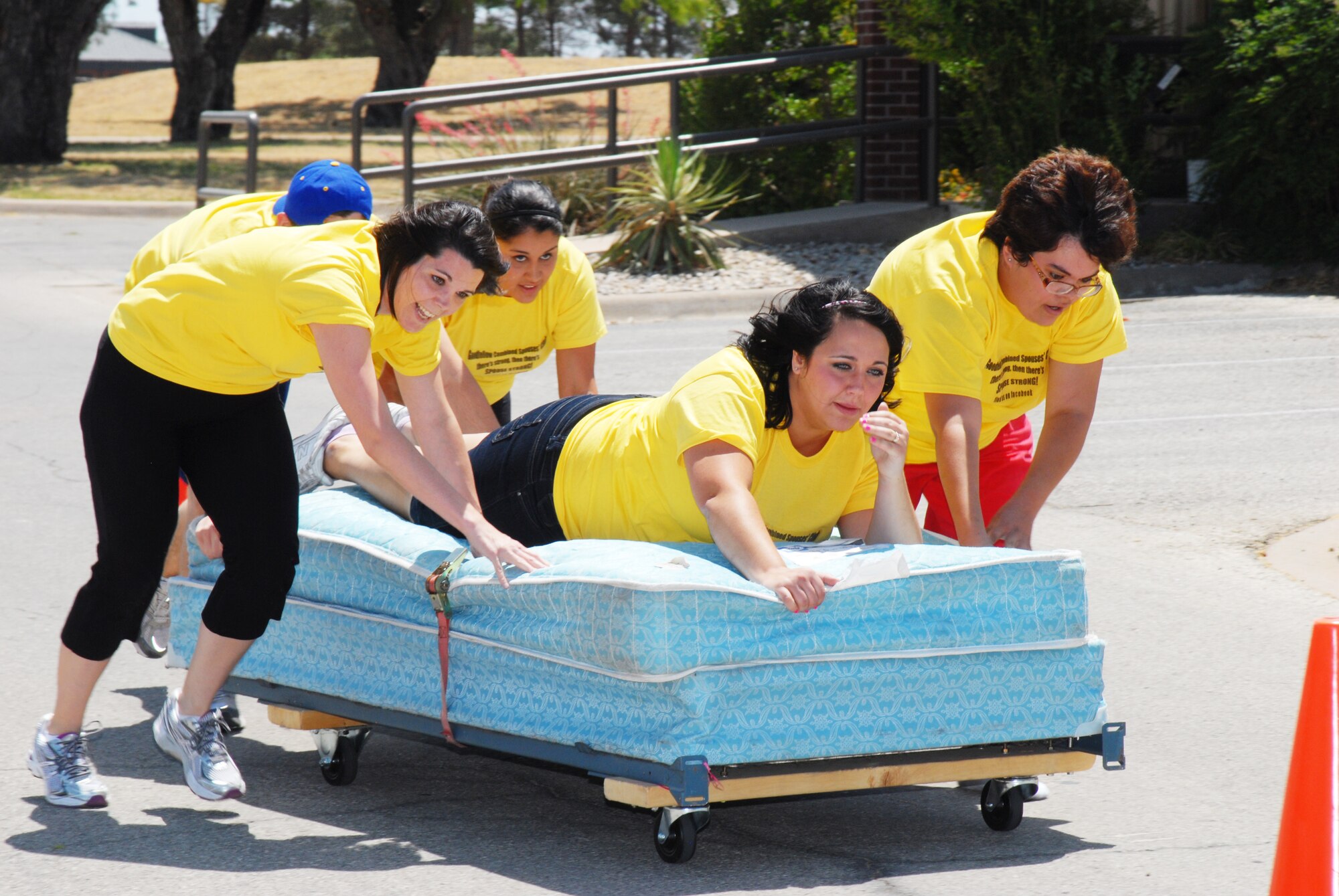 The Goodfellow Combined Spouses Club pushes their way through the cones during the bed race, April 30. The goal was to go through an obstacle course and then push a teammate on a bed through cones and across the finish line with the fastest time. (U.S. Air Force photo/Airman 1st Class Michael Smith)