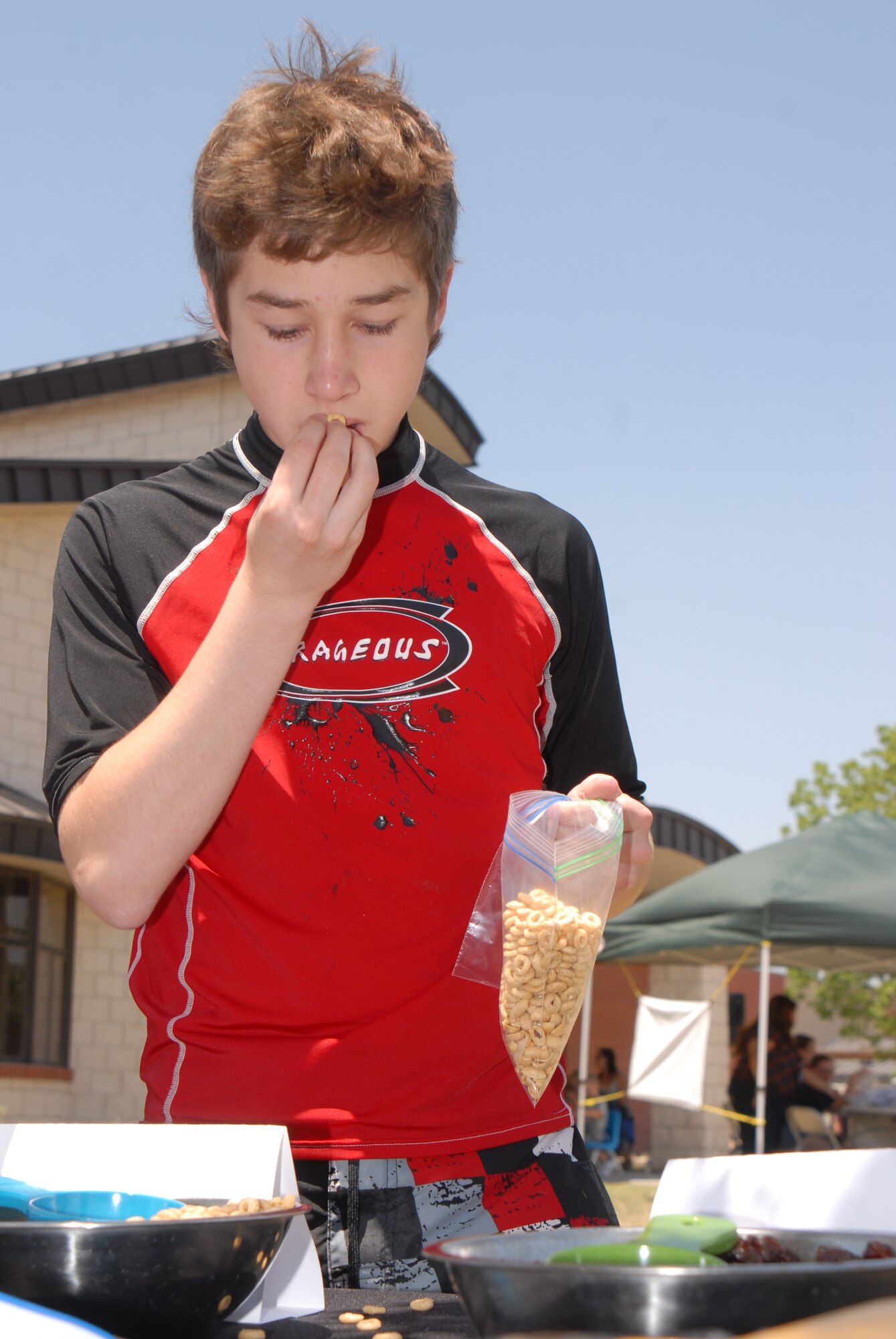 Cobi Alloway makes a healthy snack of trail mix at the Children's Festival, April 30. The Children's Festival had many games and attractions for families. (U.S. Air Force photo/Airman 1st Class Michael Smith)