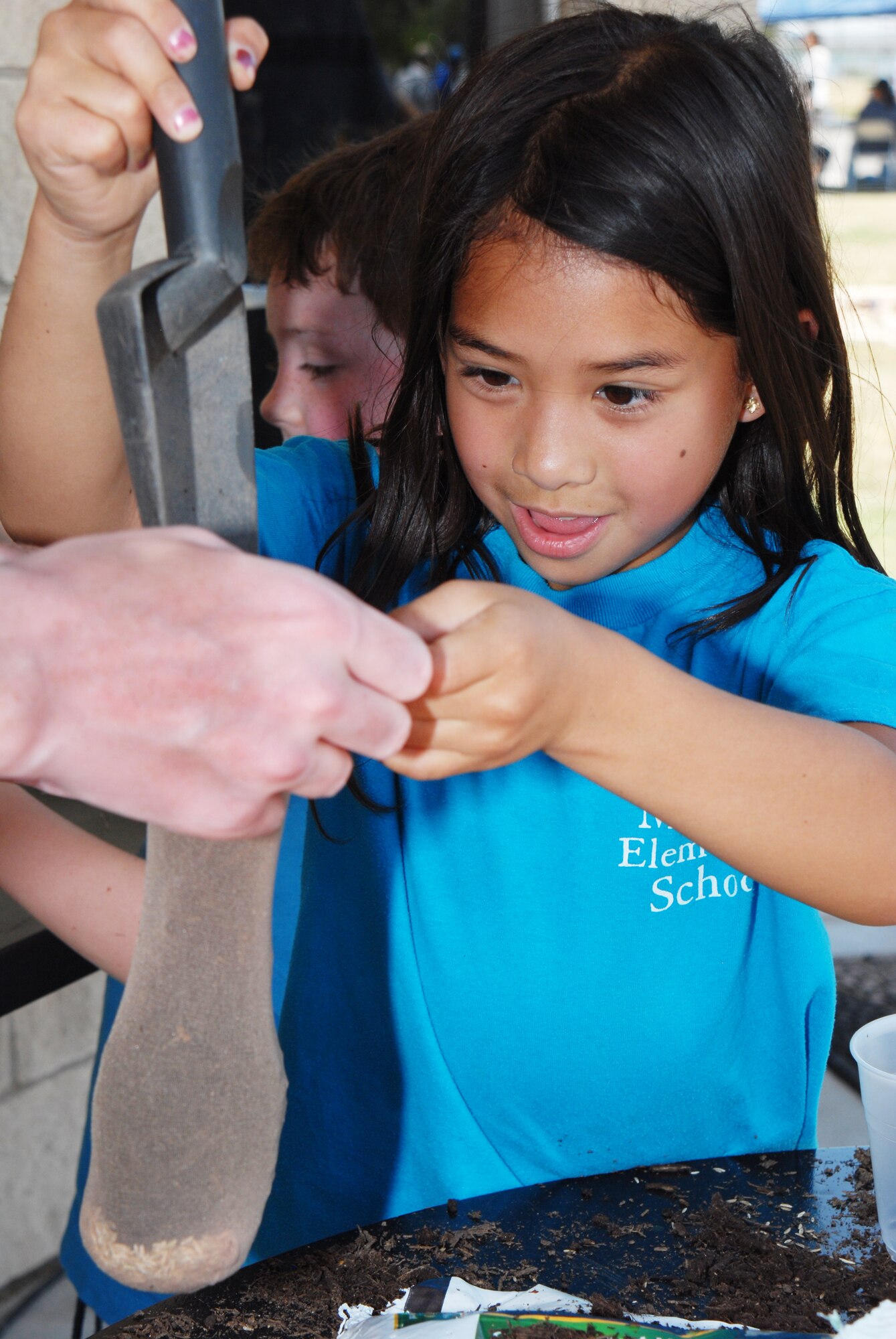 Mia Casipe makes a stocking plant puppet at the Children's Festival, April 30. The Children's Festival had many games and attractions for families. (U.S. Air Force photo/Airman 1st Class Michael Smith)