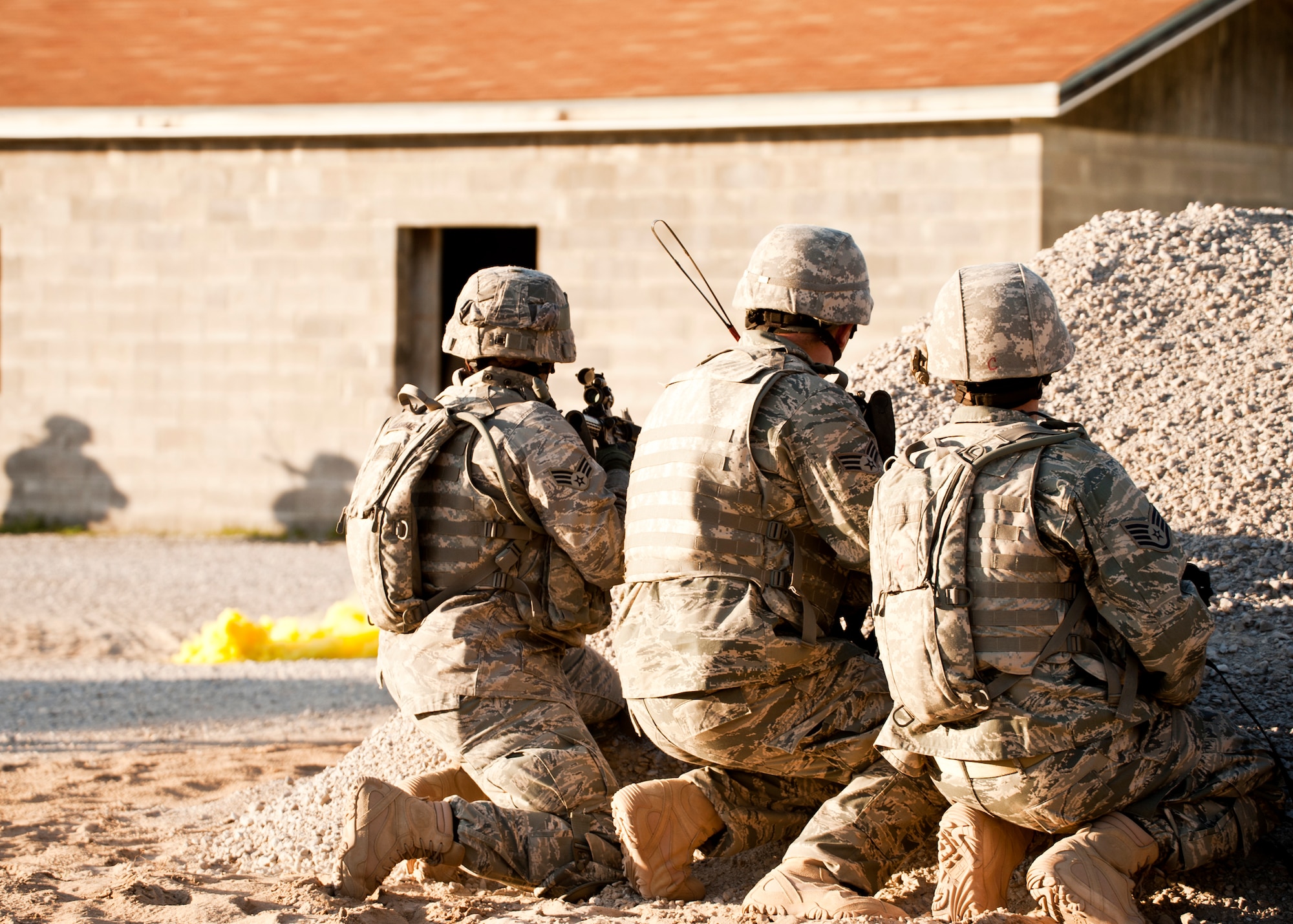 Security Forces Airmen watch as others move toward a building during a raid on a village as part of an exercise April 29 at Eglin Air Force Base, Fla.  Based on intelligence gathered, two squads entered the village in search of a high value target.  This was part of Air Force Materiel Command’s "Brave Defender" training, which is administered by the 96th Ground Combat Training Squadron.  GCTS instructors push 10 training classes a year, which consists of improvised explosive device detection and reaction, operating in an urban environment, mission planning, land navigation and casualty care.  The three-week training culminates with a three-day field training exercise where the Airmen apply what they learned in combat scenarios.  More than 140 Airmen from more than 10 locations attended this training.  (U.S. Air Force photo/Samuel King Jr.)