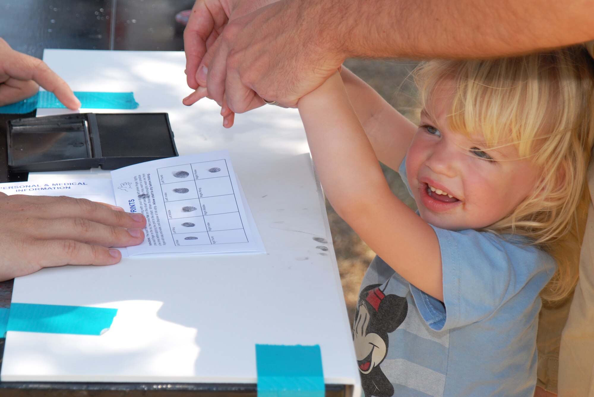 Rebecca Kreuzer gets her fingerprints taken at the Children's Festival, April 30. The fingerprints are used as a safeguard in case the child is lost or kidnapped. (U.S. Air Force photo/Airman 1st Class Michael Smith)