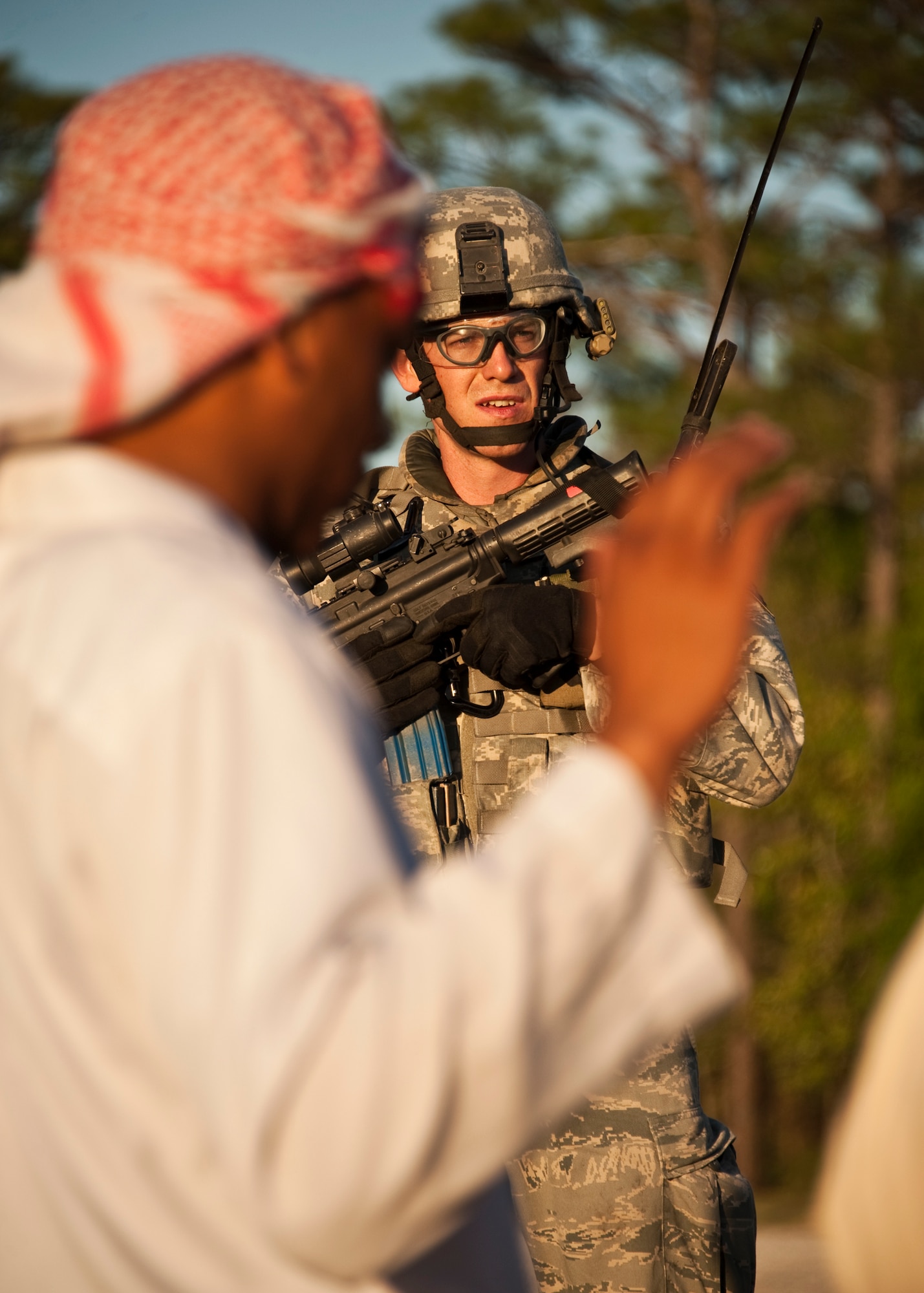 Senior Airman Benjamin Thompson, 375th Security Forces Squadron, watches the interrogation of suspects during a vehicle stop as part of an exercise April 29 at Eglin Air Force Base, Fla.  This was part of Air Force Materiel Command’s "Brave Defender" training, which is administered by the 96th Ground Combat Training Squadron.  GCTS instructors push 10 training classes a year, which consists of improvised explosive device detection and reaction, operating in an urban environment, mission planning, land navigation and casualty care.  The three-week training culminates with a three-day field training exercise where the Airmen apply what they learned in combat scenarios.  More than 140 Airmen from more than 10 locations attended this training.  (U.S. Air Force photo/Samuel King Jr.)