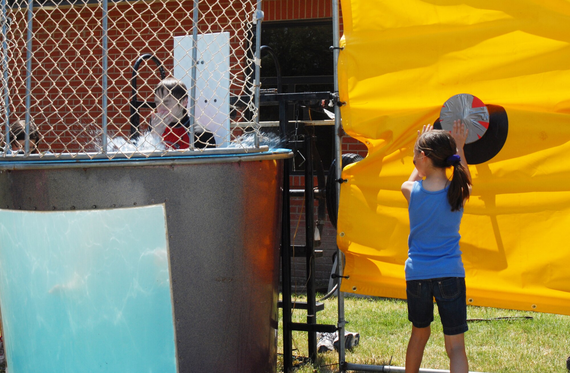 Ashley Hempel gives Cobi Alloway a refeshing plunge into the dunking booth at the Children's Festival, April 30. The Children's Festival had many games and attractions for all of the family to enjoy. (U.S. Air Force photo/Airman 1st Class Michael Smith)