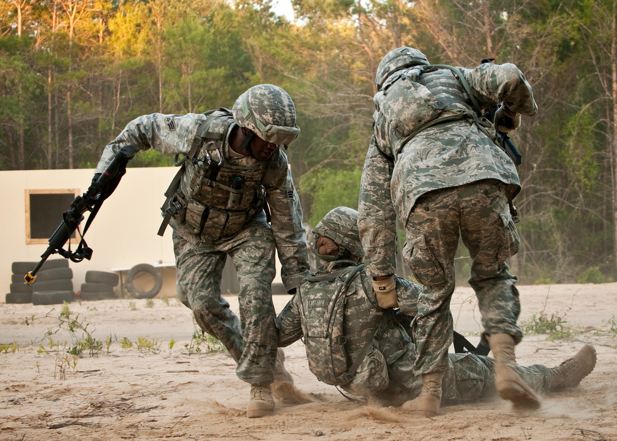 Airmen drag their “wounded” teammate to safety after she was hit in a firefight during a raid on a village as part of an exercise April 29 at Eglin Air Force Base, Fla.  Based on intelligence gathered, two squads entered the village in search of a high value target.  This was part of Air Force Materiel Command’s "Brave Defender" training, which is administered by the 96th Ground Combat Training Squadron.  GCTS instructors push 10 training classes a year, which consists of improvised explosive device detection and reaction, operating in an urban environment, mission planning, land navigation and casualty care.  The three-week training culminates with a three-day field training exercise where the Airmen apply what they learned in combat scenarios.  More than 140 Airmen from more than 10 locations attended this training.  (U.S. Air Force photo/Samuel King Jr.)