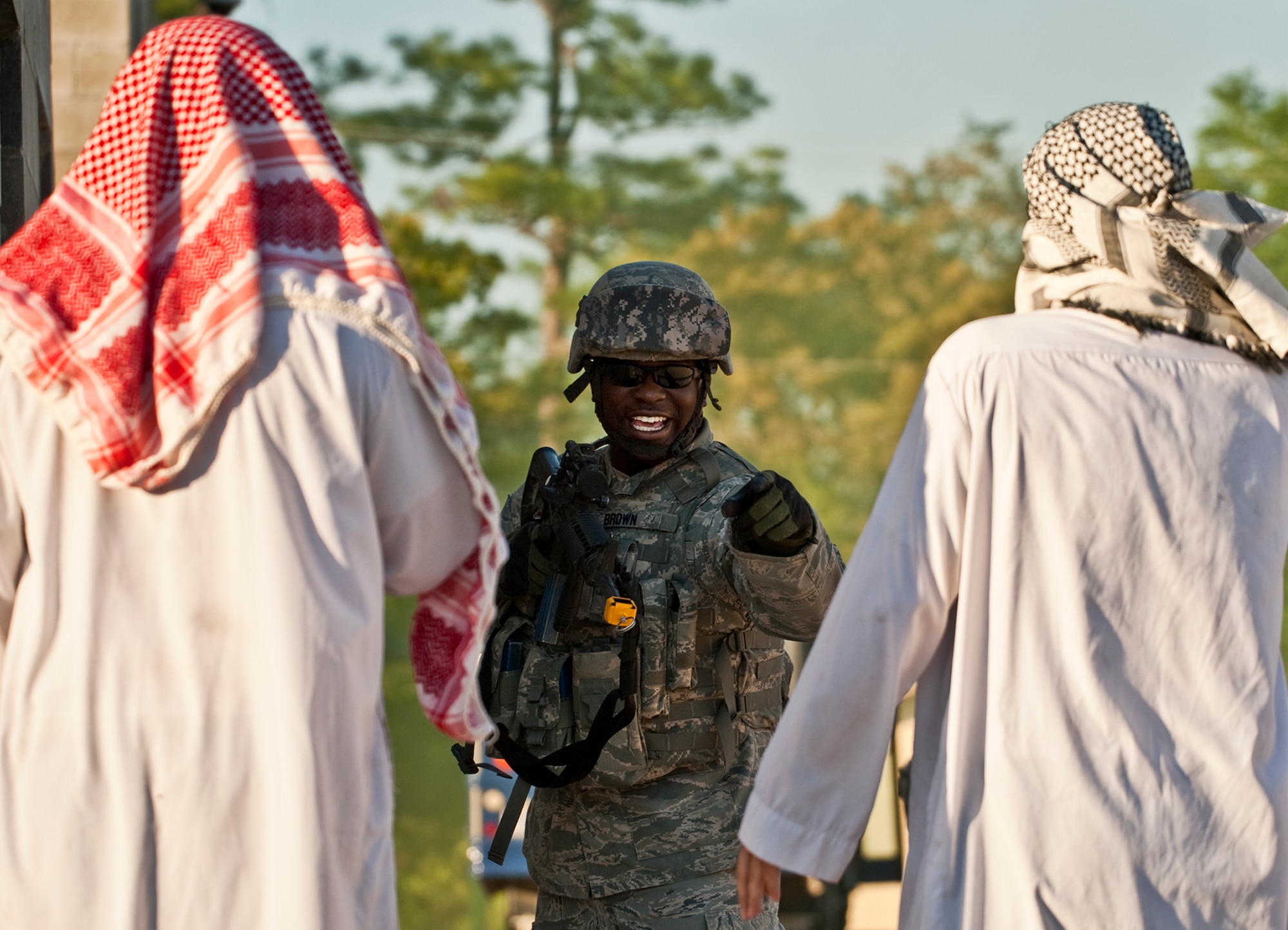 Senior Airman Bobby Brown, 375th Security Forces Squadron, tells villagers to get down during a raid exercise on a village April 29 at Eglin Air Force Base, Fla.  Based on intelligence gathered, two squads entered the village in search of a high value target.  This was part of Air Force Materiel Command’s "Brave Defender" training, which is administered by the 96th Ground Combat Training Squadron.  GCTS instructors push 10 training classes a year, which consists of improvised explosive device detection and reaction, operating in an urban environment, mission planning, land navigation and casualty care.  The three-week training culminates with a three-day field training exercise where the Airmen apply what they learned in combat scenarios.  More than 140 Airmen from more than 10 locations attended this training.  (U.S. Air Force photo/Samuel King Jr.)