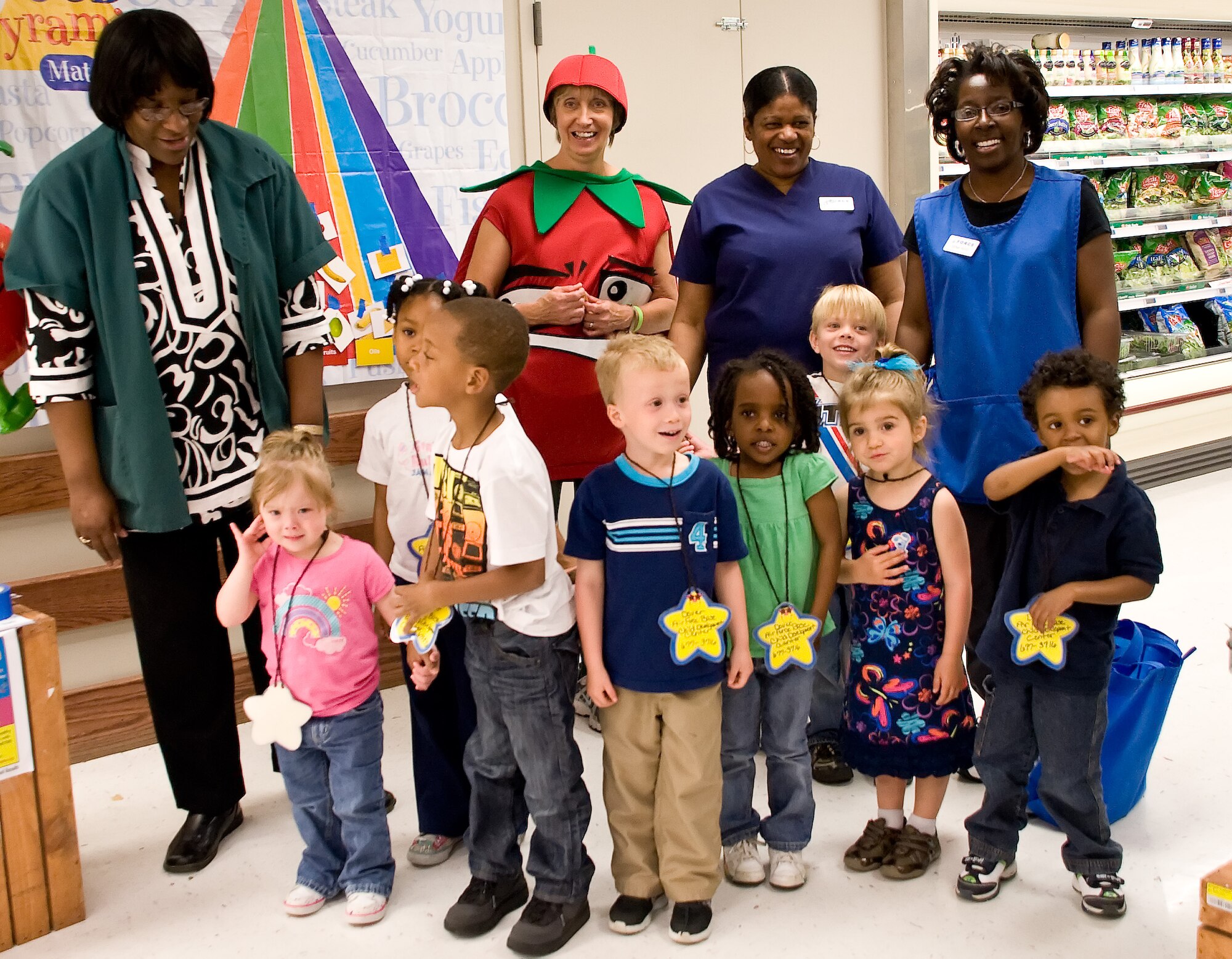 Kate Jennings, 436th Medical Group nutritionist and temporary tomato, meets with children from the Child Development Center April 28, 2011 at the Dover Air Force Base, Del., commissary. The Month of the Military Child event encouraged children to eat more fruits and vegetables. They were given an “eater meter,” which tracks the amounts of fruits and vegetables they eat. When they fill out the meter they return it to the commissary and are entered into a drawing for a bicycle.  (U.S. Air Force photo by Adrian Rowan)