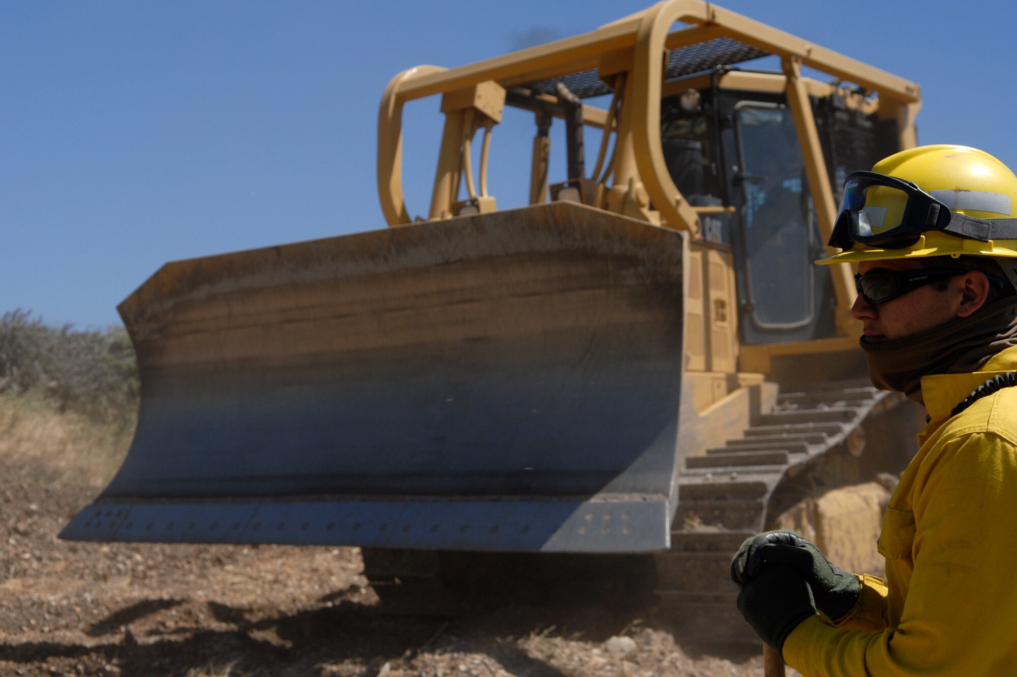 VANDENBERG AIR FORCE BASE, Calif. -- Senior Airman Brayan Rosales, a 30th Civil Engineer Squadron fire dozer team member, trains as a swamper during the Fire Dozer Academy here Thursday, April 28, 2011.  A swamper aids the bulldozer operator to ensure there are no obstructions or hazards in their path.  (U.S. Air Force photo/Staff Sgt. Andrew Satran) 

   