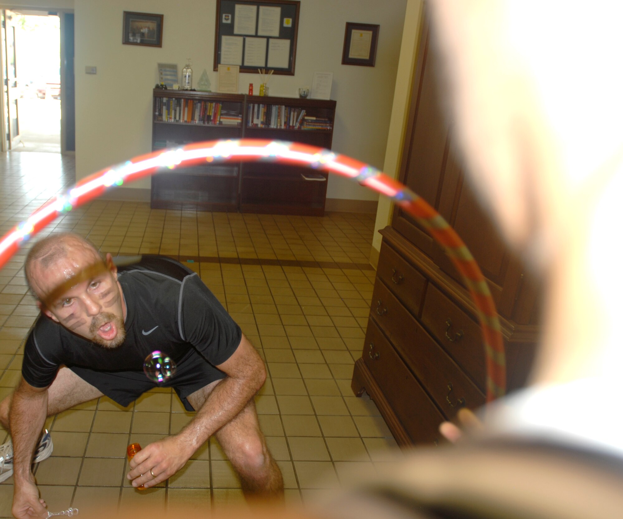 GOODFELLOW AIR FORCE BASE, Texas— Kelly Dunn, a member of team “Road Warriors,” attempts to blow a bubble threw a hoop during the SARC Challenge, April 30. The nearly five-mile race was coordinated by Donna Casey, the base Sexual Assault Response Coordinator, to raise Sexual Assault Awareness.  (U.S. Air Force photo/Airman 1st Class Jessica Keith)