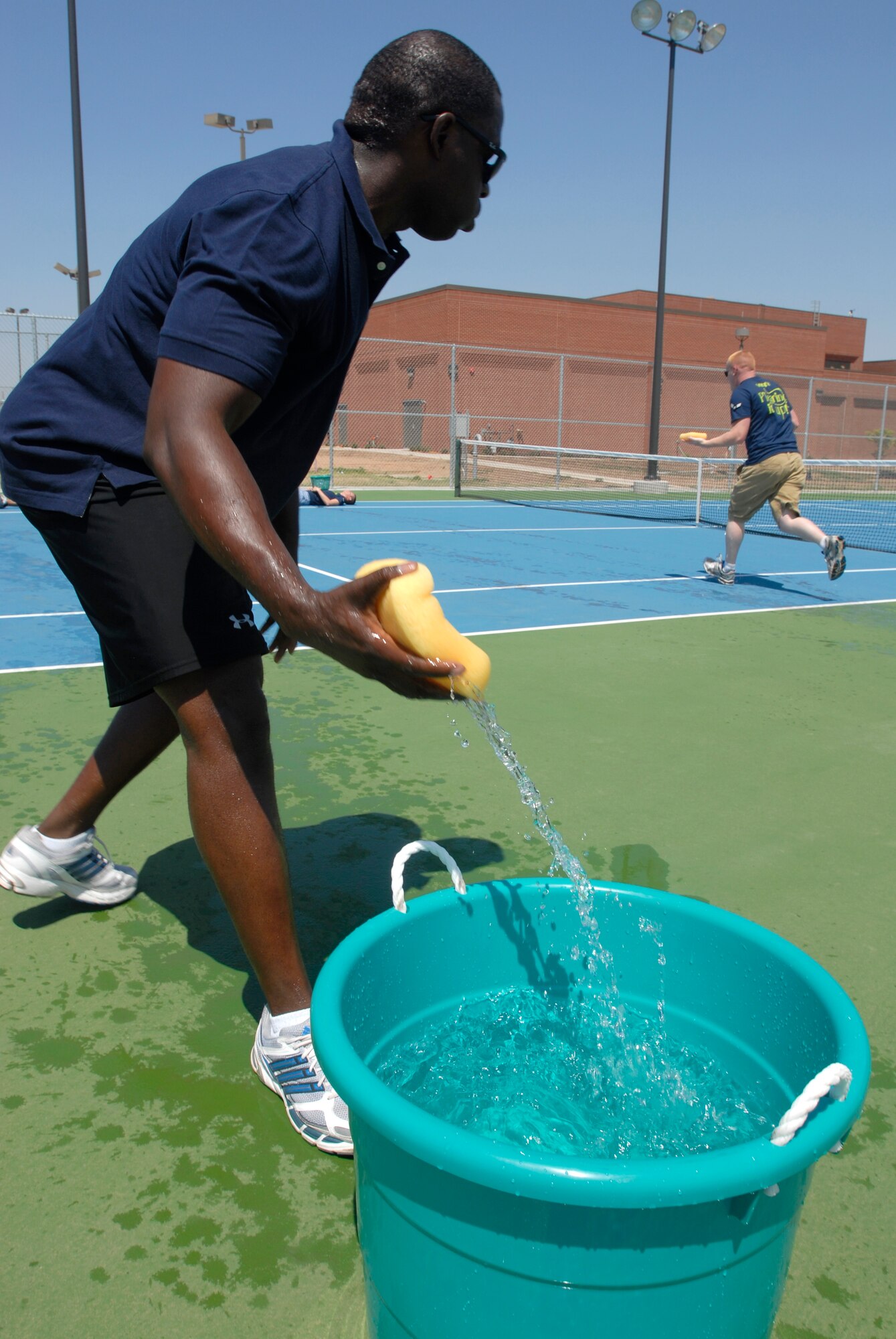 GOODFELLOW AIR FORCE BASE, Texas— Master Sgt. Christopher Howard, the First Sergeant for the 312th Training Squadron and  member of team “Shirts,” races to fill a bucket with water using only a sponge, during the SARC Challenge April 30.  The challenge, meant to end Sexual Assault Awareness Month with a bang, consists of a nearly five-mile course, and 12 tasks with informative facts about Sexual Assault Awareness. (U.S. Air Force photo/Airman 1st Class Jessica Keith)