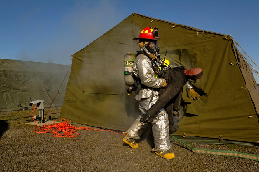 A firefighter from the 92nd Civil Engineering Squadron rescues a simulated victim during the field training exercise April 22, 2011, at Fairchild Air Force Base, Wash. The purpose of this training was to simulate real-time training in the battlefield. The 92nd CES conducted an a four-day exercise for members of the unit to give each Airmen a better picture of what is expected of them in a combat environment. (U.S. Air Force Photo/Tech. Sgt. J.T. May III) 