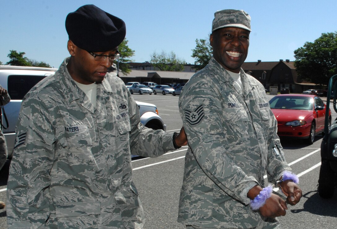 Staff Sgt. Lamar Waters, 633d Security Forces Squadron physical security, arrests Tech. Sgt. Reginald Powell, 633d Medical Group Family Health Center non-commissioned officer-in-charge, during a Jail and Bail Air Force Assistance Fund fundraiser Friday at Langley Air Force Base, Va., April 29, 2011. Langley Airmen issued warrants having friends, coworkers and leadership arrested by security forces and put in mock jail cells at the Base Exchange. (U.S. Air Force photo by Staff Sgt. Jeff Nevison/Released)