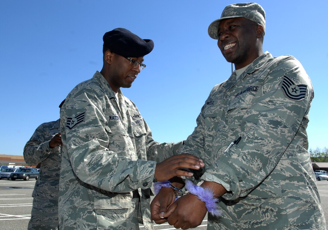 Staff Sgt. Lamar Waters, 633d Security Forces Squadron physical security, arrests Tech. Sgt. Reginald Powell, Family Health Center noncommissioned officer-in-charge, during a Jail and Bail fundraiser at Langley Air Force Base, Va., April 29, 2011. The 633 SFS sponsored the event as a fun way for Langley personnel to raise money to be donated to the Air Force Assistance Fund. (U.S. Air Force photo by Staff Sgt. Jeff Nevison/Released)  