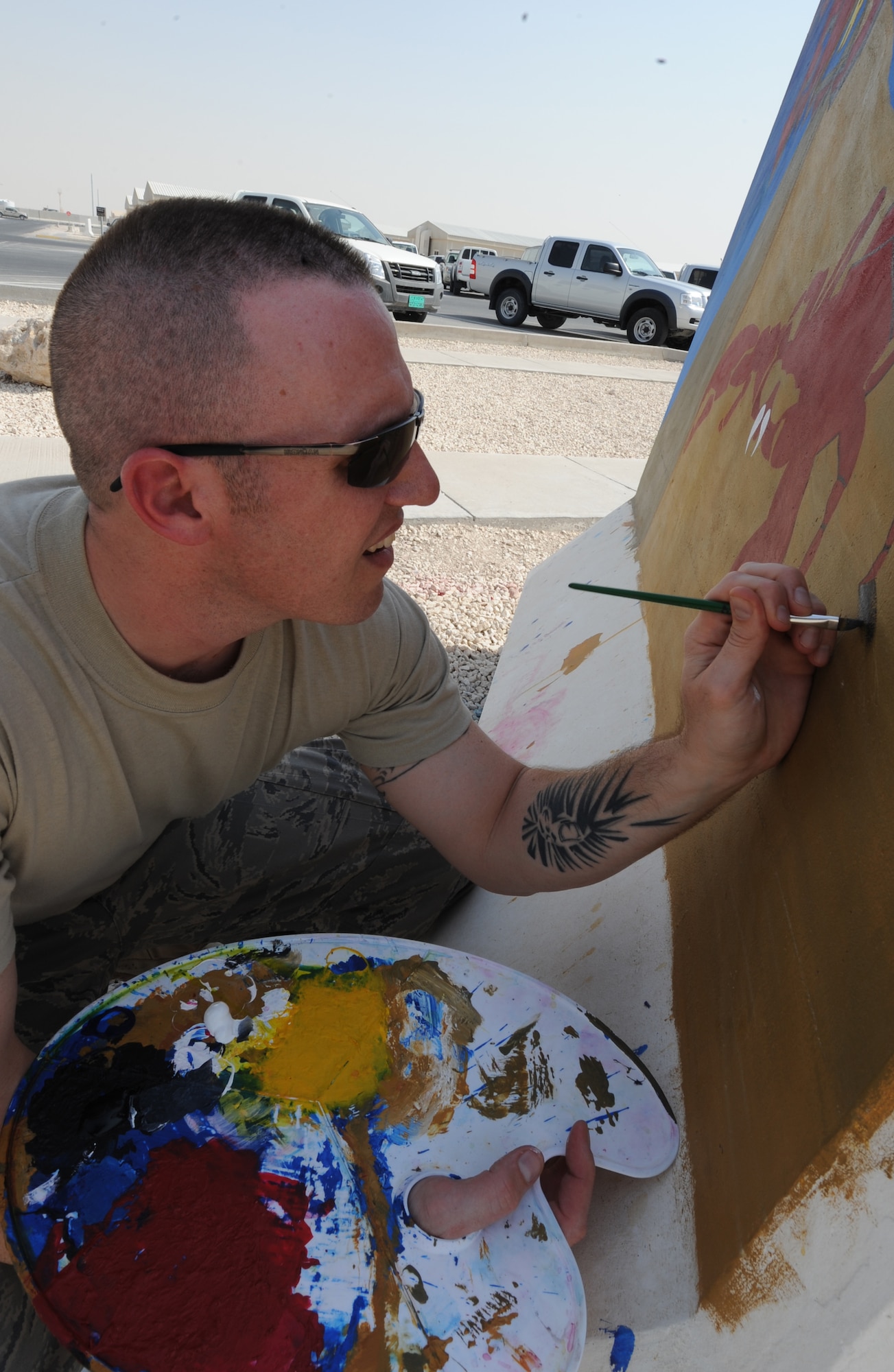 Tech. Sgt. Jason Grimes, 379th Expeditionary Maintenance Operations Squadron, paints the barrier for his squadron in Southwest Asia. Throughout base barriers are painted to demonstrate squadron spirit.  (U.S. Air Force photo/Staff Sgt. Liliana Moreno)