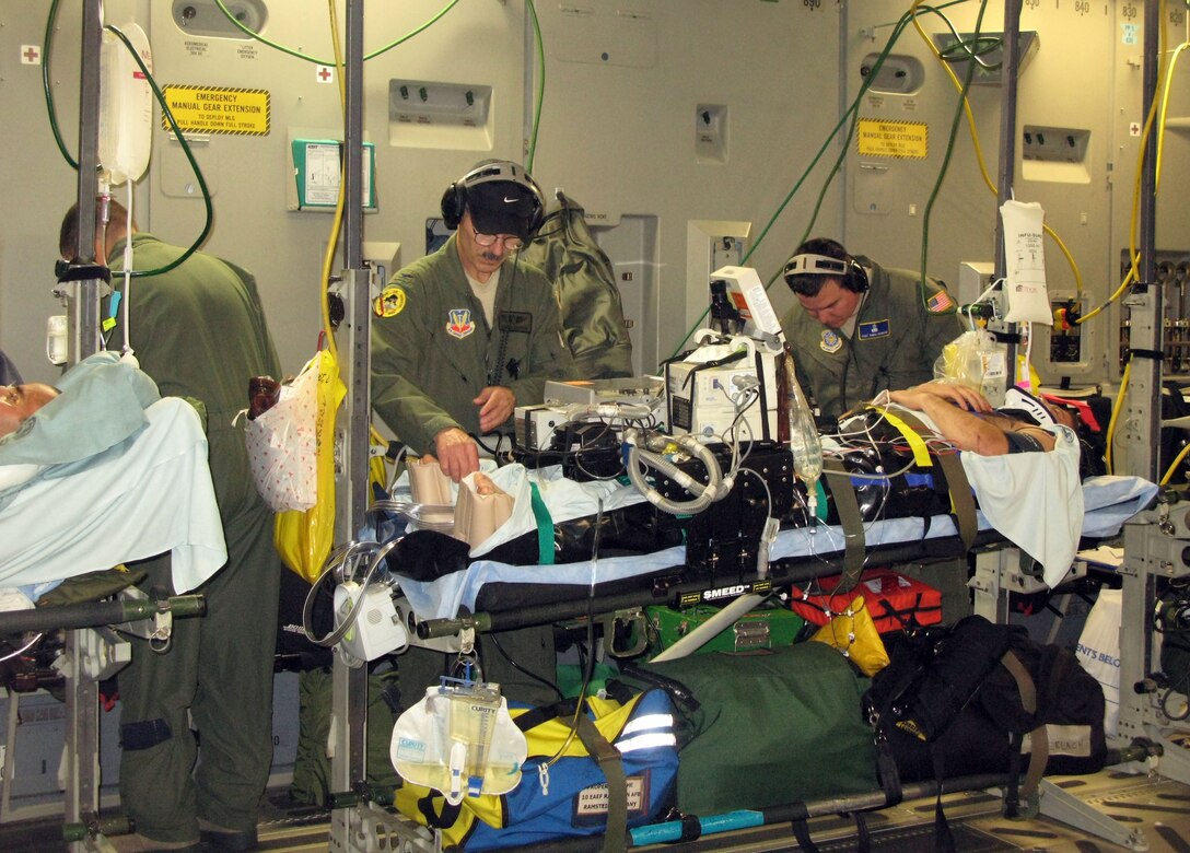 A three-member Air National Guard critical care air transport team, armed with hundreds of pounds of medical gear that transforms a military aircraft into a flying intensive-care unit, treats critically wounded and ill patients during a flight from Ramstein Air Base, Germany, to Joint Base Andrews, Md., April 29, 2011. Team members, from left, are Air Force Lt. Col. David Worley, Air Force Col. (Dr.) Charles Chappuis and Air Force Tech. Sgt. Chris Howard. DOD photo by Donna Miles