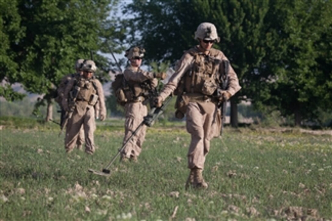 U.S. Marine Corps Cpl. Ben W. Gibson (right), with 2nd Combat Engineer Battalion, 1st Battalion, 5th Marines Regiment, Regimental Combat Team 8, sweeps for explosive devices with a metal detector during a reconnaissance patrol in Sangin, Afghanistan, on April 22, 2011.  U.S. Marines conduct reconnaissance patrols to survey the local populace and maintain familiarity with the area of operations.  