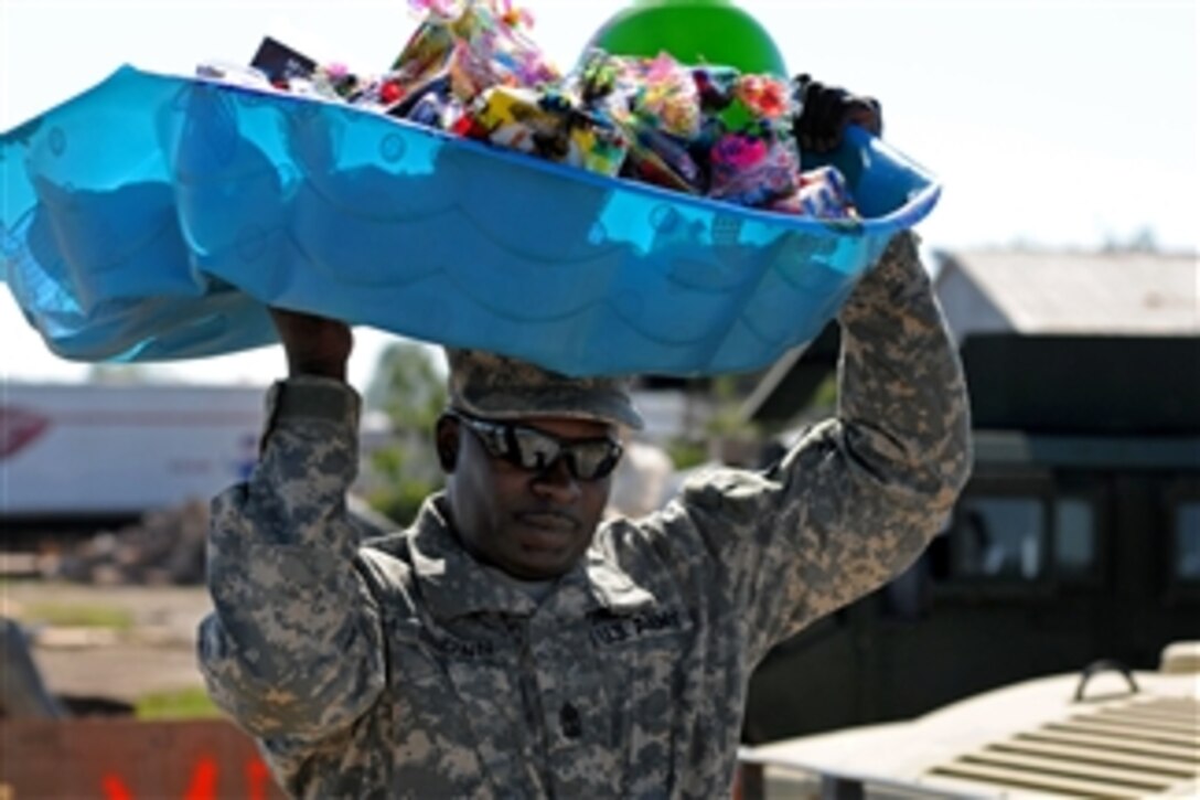 U.S. Army 1st Sgt. Dwight D. Brown carries supplies to help citizens of Smithville, Miss., as the community copes with severe tornado damage on April 29, 2011.  Brown is assigned to the A Troop, 1st Battalion, 98th Cavalry Regiment, Mississippi Army National Guard.  