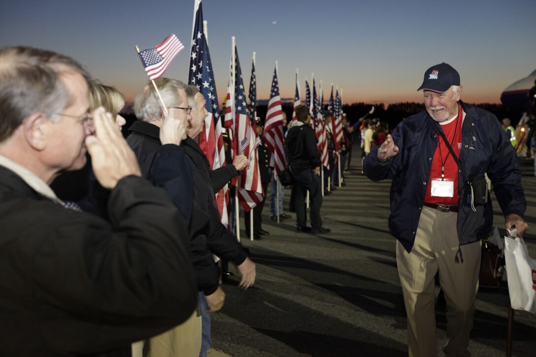 World War II veteran Terrence Walker, right, walks past an aisle of applause at the Coastal Carolina Regional Airport in New Bern, N.C., in appreciation of him and 107 of his fellow WWII veterans. The non-profit organization Honor Flight Southeastern North Carolina flew the veterans to visit the WWII Memorial in Washington, D.C., May 4. “I’m so overwhelmed right now,” Walker said of the reception. “I’m at a loss for words.”