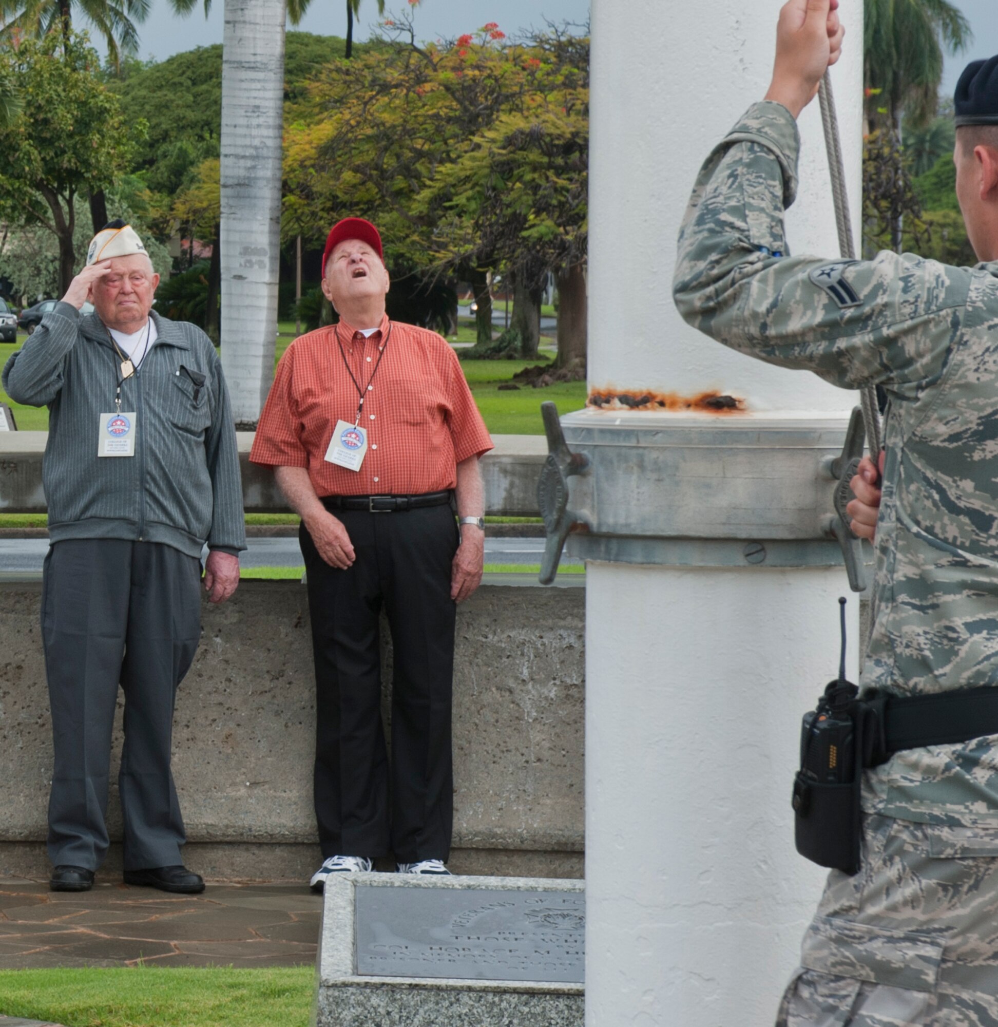 World War II veterans Guy Piper of the U.S. Navy and Parke Piper of the U.S. Marine Corps salute the raising of the American flag in Atterbury circle during a visit to Joint Base Pearl Harbor-Hickam, Hawaii May 3. During their stay, the veterans also visited Atterbury Circle, the Pacific Air Forces headquarters building, and the missing man formation. (U.S. Air Force photo/Staff Sgt. Nathan Allen)