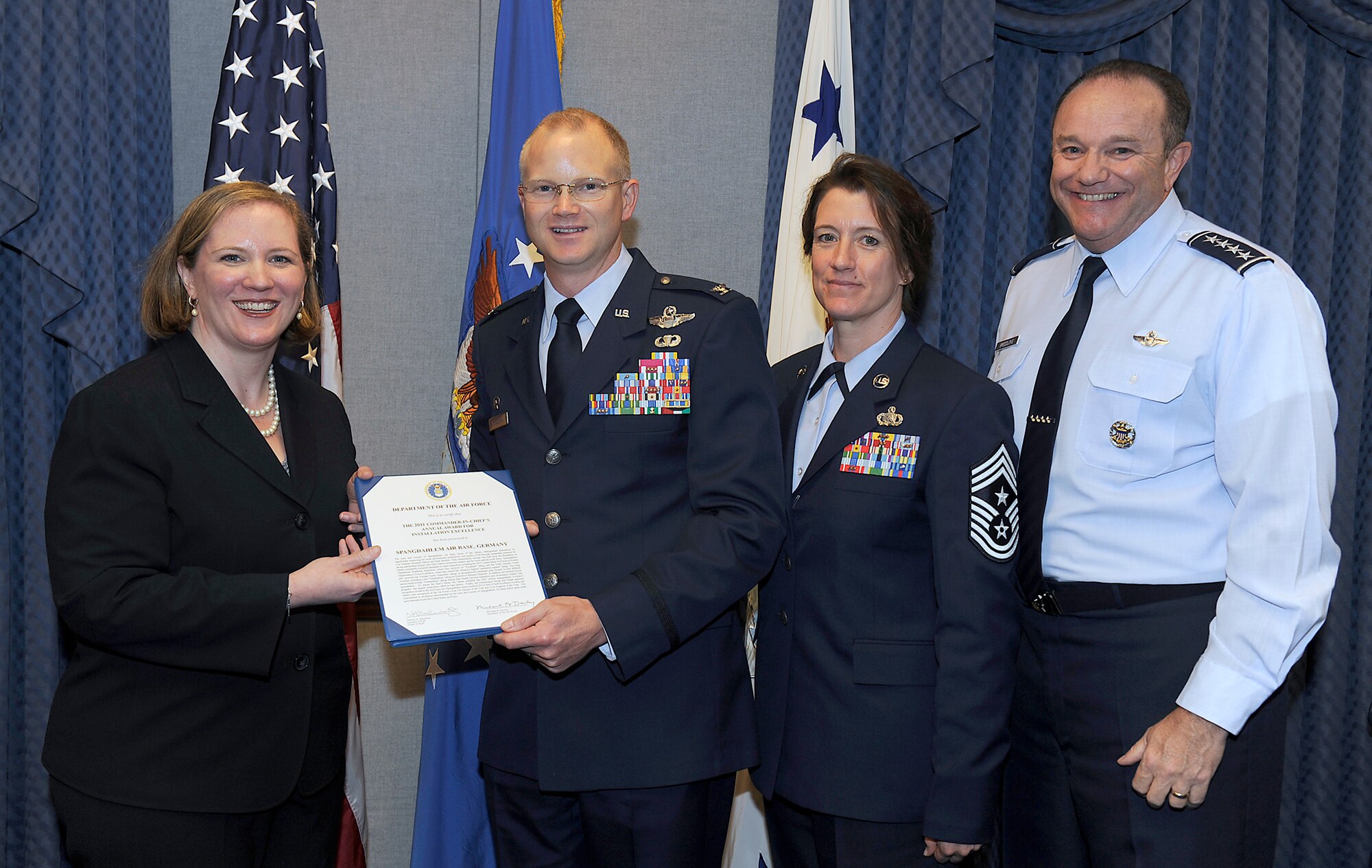 Undersecretary of the Air Force Erin Conaton presents the 2011 Commander in Chief's Installation Excellence Award to Col. Christopher Weggeman, the commander of the 52nd Fighter Wing at Spangdahlem Air Base, Germany, and Chief Master Sgt. Sandra Miller, 52nd FW command chief, as Air Force Vice Chief of Staff Gen. Philip Breedlove looks on. The award presentation took place May 3, 2011, during a ceremony in the Pentagon. (U.S. Air Force photo/Scott Ash)