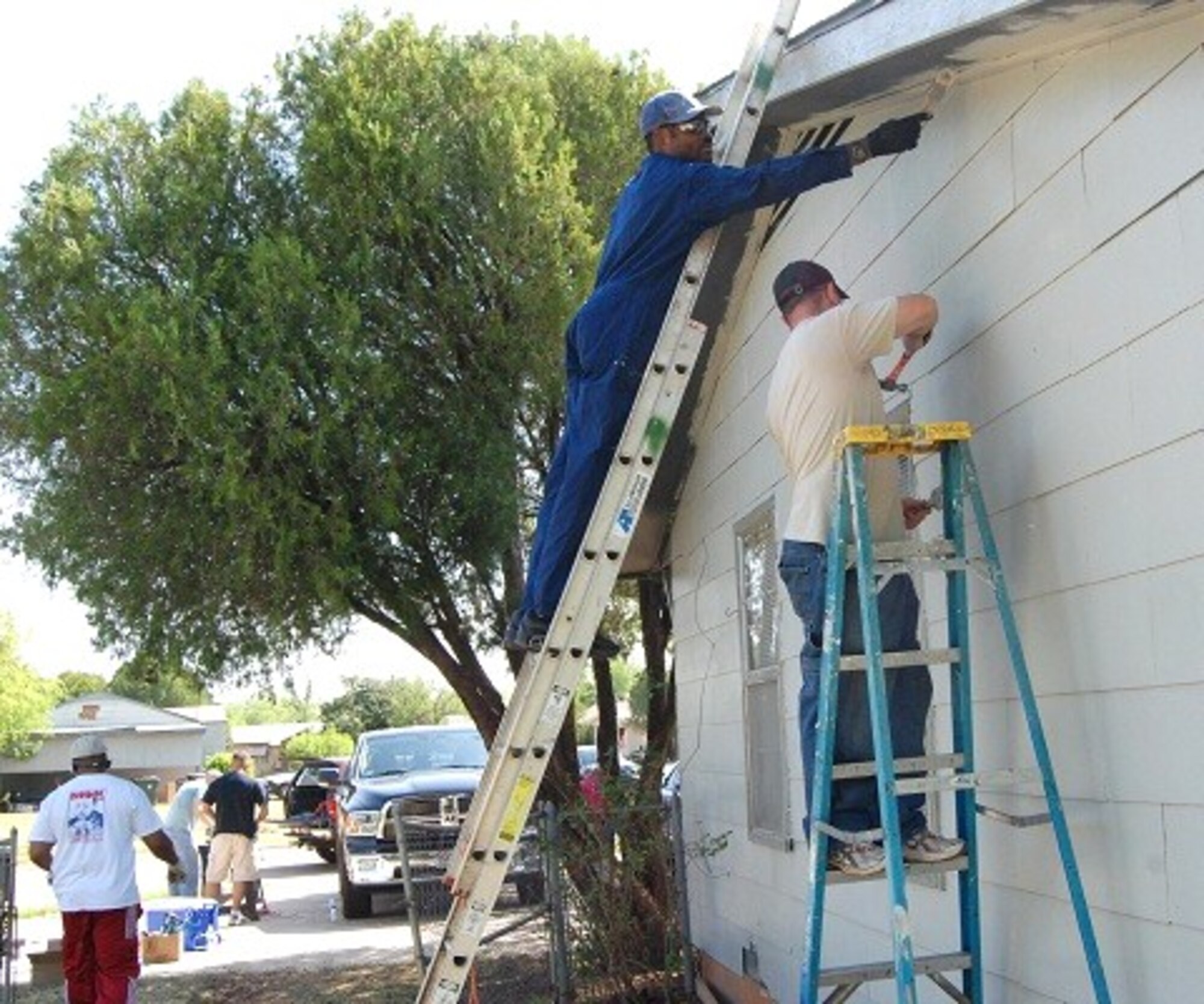 Tech. Sgt. Allen Young, 366th Training Squadron Electrical Section Chief aims high while Staff Sgt. Josh Mahan, 82 Contracting Squadron, secures siding for a Christmas in Action home in Wichita Falls, Texas April 30.  Both sergeants have volunteered for several years as a way to give back to the community.  (U.S. Air Force photo/Debi Smith)
