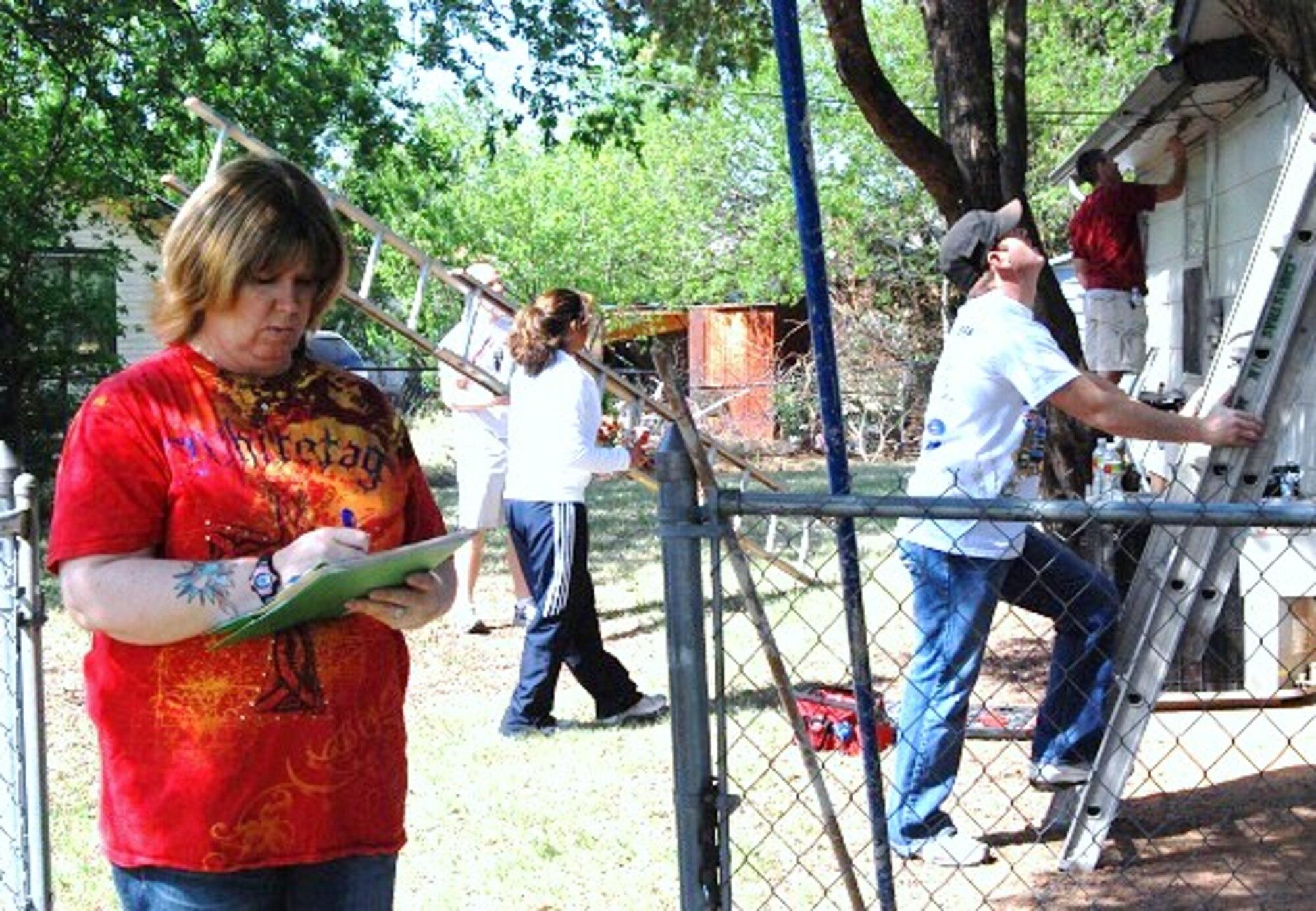 Melissa Guillory, a member of the 82nd Civil Engineering Squadron and first time Christmas in Action team captain, reviews the progress list for a home project that needed paint, siding and door replacement in Wichita Falls, Texas April 30.  Ms. Guillory’s ‘CE Team’ included 27 volunteers from five units across base.  Sheppard volunteers managed 37 of the 45 homes selected for this year's event. The volunteer project came in under budget at $445, saving the homeowner $9,000. (U.S. Air Force photo/Debi Smith)
