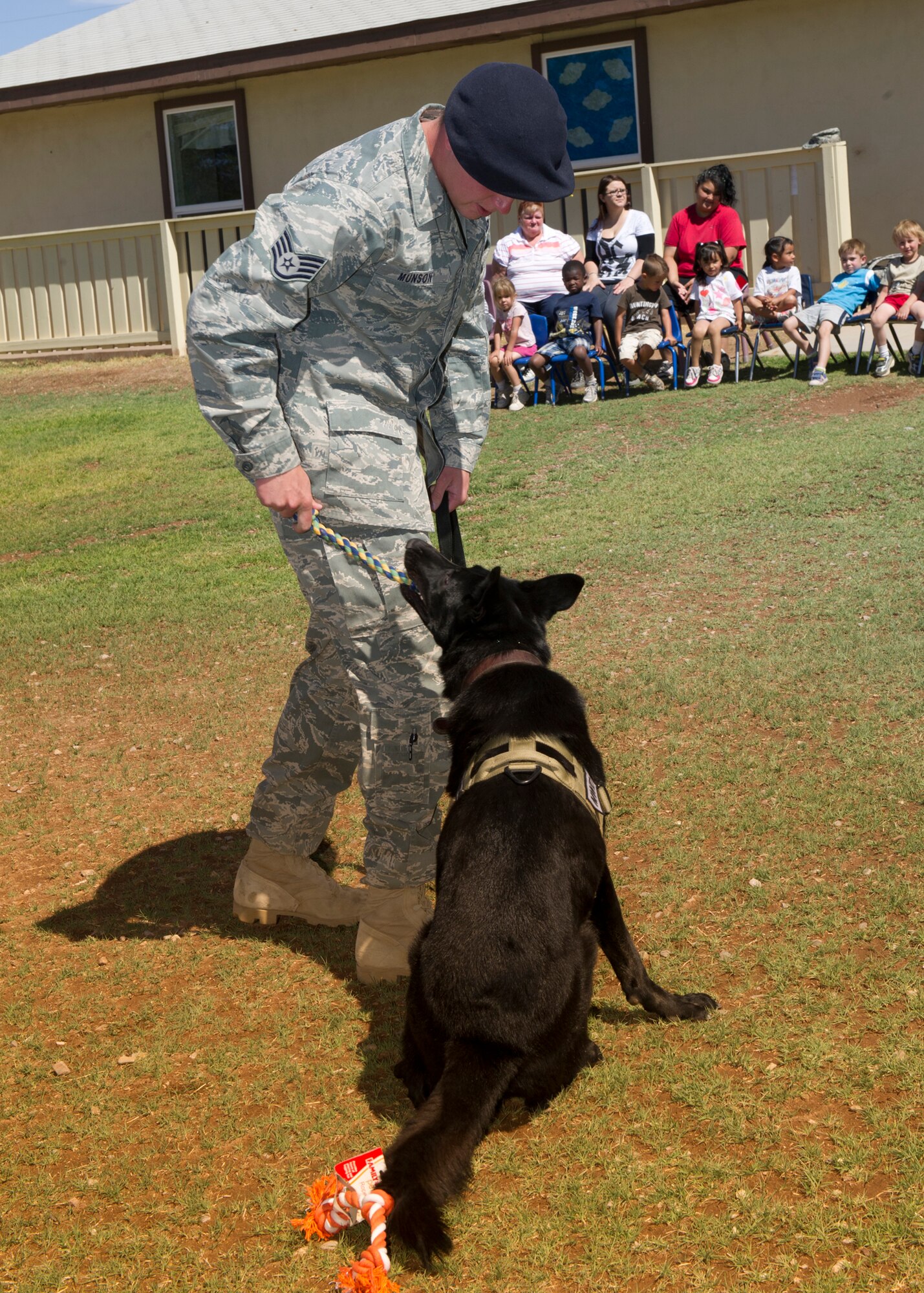 ALAMOGORDO, N.M. -- Staff Sgt. Joel Munson, 49th Military Working Dog Section at Holloman Air Force Base, handles MWD “Ate” April 29, 2011, at the Full House Child Development Center. Children from the center donated dog toys for deployed MWD’s. To show their gratitude, some of the handlers entertained the children and staff with a demonstration including tricks and commands. (U.S. Air Force photo by Airman 1st Class Eileen Payne/Released)