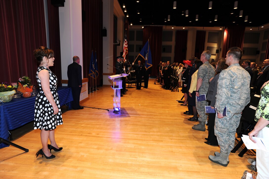 Mrs. Shelley Waite sings the National Anthem during the promotion ceremony for her husband, Colonel A. Phillip Waite, on April 29 in Gabriel Hall at Historic Hanger 2, Joint Base Anacostia-Bolling, Washington, D.C.  Colonel Waite is the commander and conductor of The United States Air Force Band in Washington, D.C.  (U.S. Air Force photo by Senior Airman Christopher Ruano)