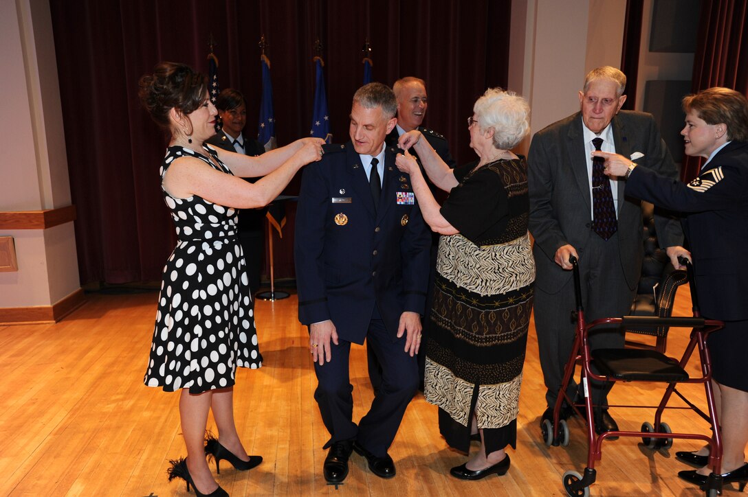 Colonel A. Phillip Waite is flanked by his parents, Allan Phillip and Sylvia Waite, and his wife, Shelley, as they help pin on his new rank--shiny silver eagles--during his promotion ceremony on April 29 at Historic Hanger 2, Joint Base Anacostia-Bolling, Washington, D.C.  Colonel Waite is the commander and conductor of The United States Air Force Band in Washington, D.C.  (U.S. Air Force photo by Senior Airman Christopher Ruano)