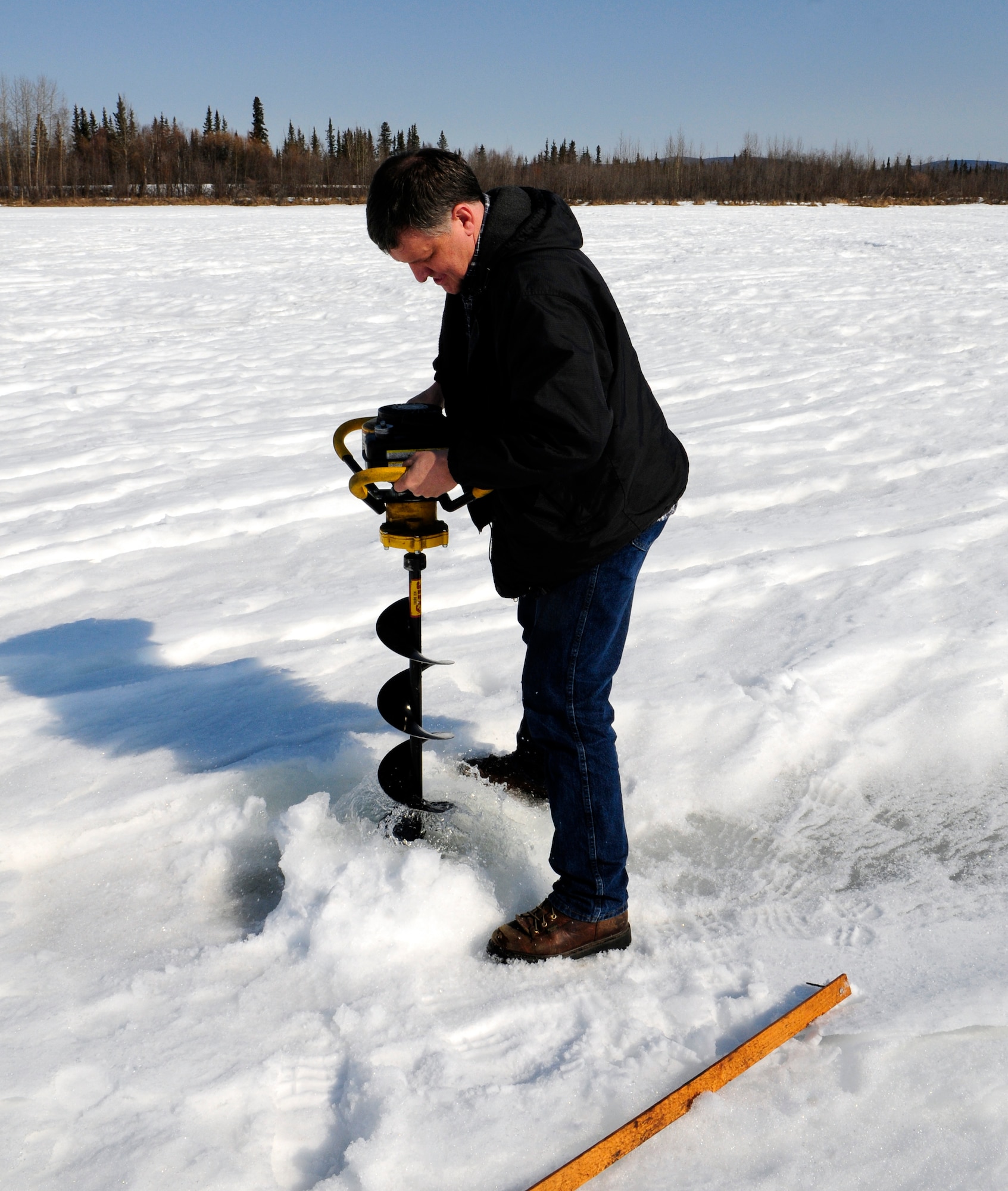 Tom Slater drills through the snow and ice to measure ice thickness April 19, 2011, Eielson Air Force Base, Alaska.  Many factors affect the thickness of ice on lakes including wind, water flow, and snow making it difficult for the average person to judge how safe it is to venture on thinning ice.  Mr. Slater is assigned to the 354th Civil Engineer Squadron as a natural resources planner. (U.S. Air Force photo/Airman 1st Class Yash Rojas)

