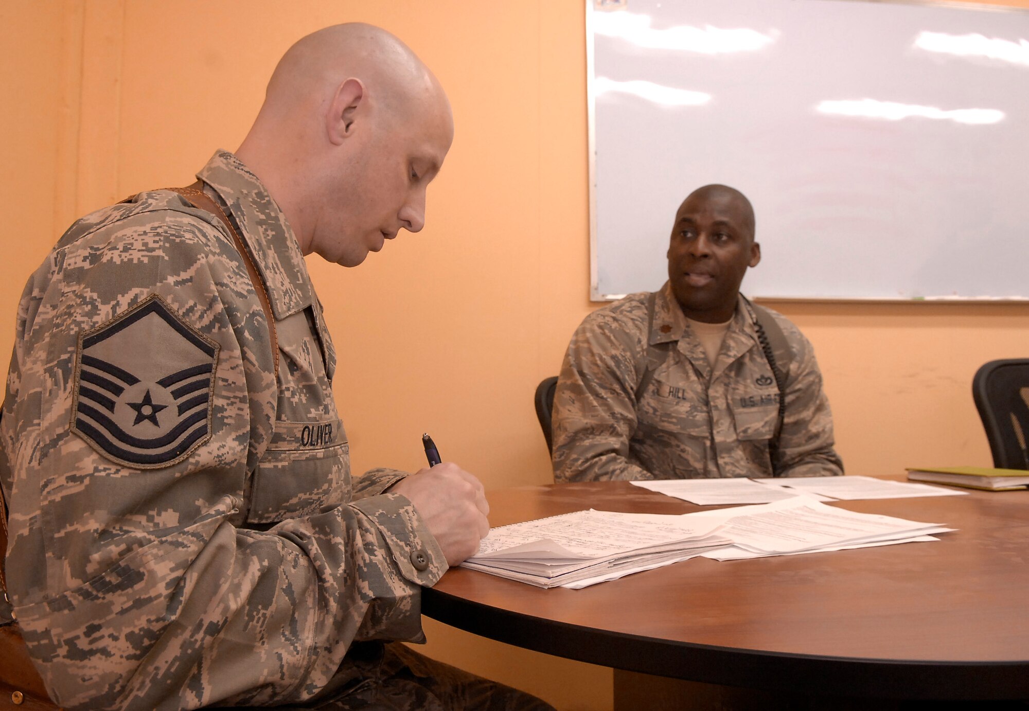 Master Sgt. Richard Oliver (left) interviews Maj. Eldrick Hill April 14, 2011, at Sather Air Base, Iraq. Sergeant Oliver is the 422nd Joint Tactics Squadron tactics, techniques and procedures flight chief. He was at Sather Air Base to conduct field interviews on graduates from the air adviser course at Joint Base McGuire-Dix-Lakehurst, N.J., seeking feedback to ensure the school is meeting operational needs. Major Hill is the Iraq Training and Advisory Mission-Air logistics lead engineer. (U.S. Air Force photo/Tech. Sgt. Randy Redman)
