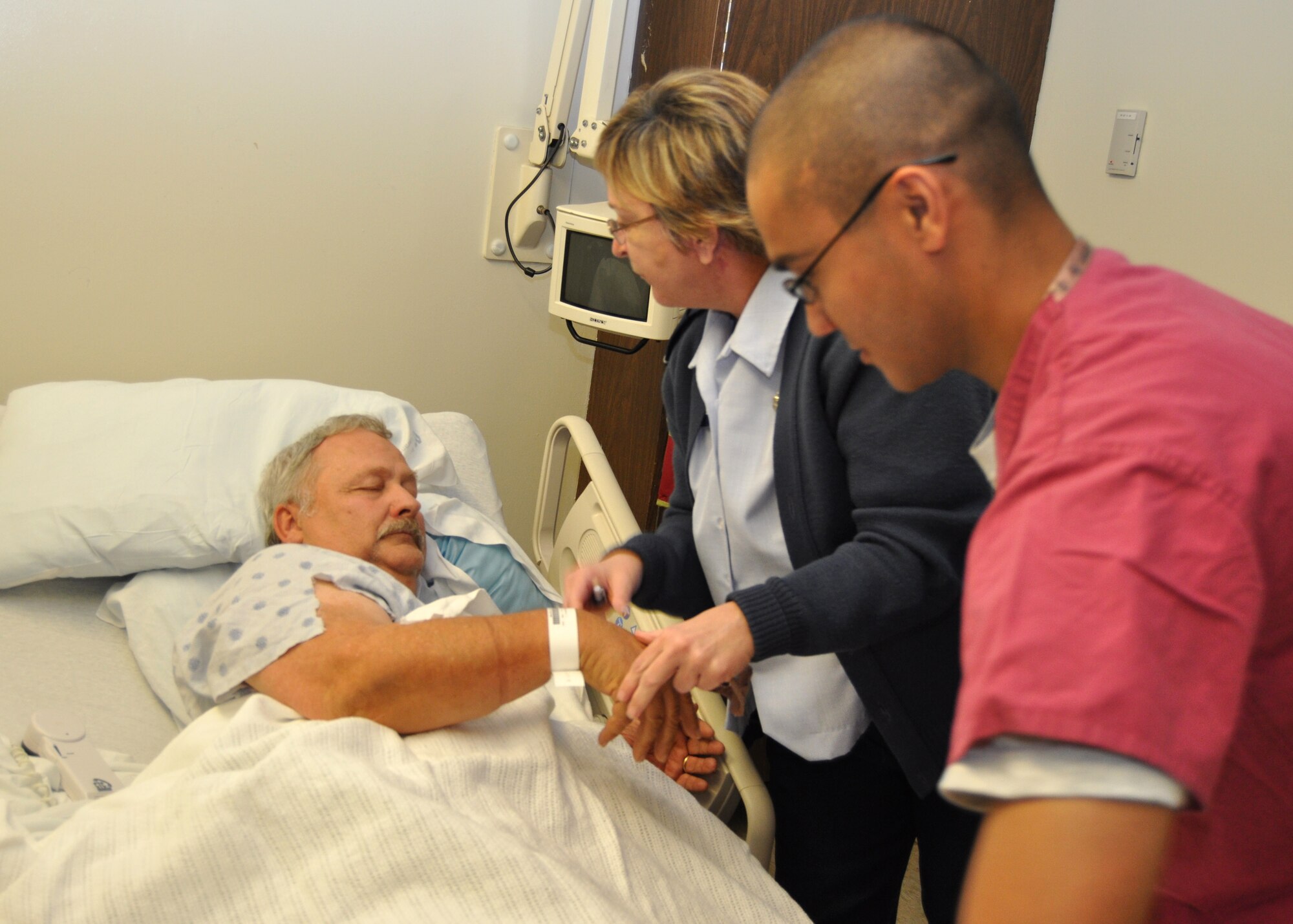 Nurse Maj. Laura Bass and medical technician Airman 1st Class Atif Siddiqui, 81st Inpatient Operations Squadron, care for David Serverns, a retired master sergeant, on the medical inpatient unit.  (U.S. Air Force photo by Steve Pivnick)