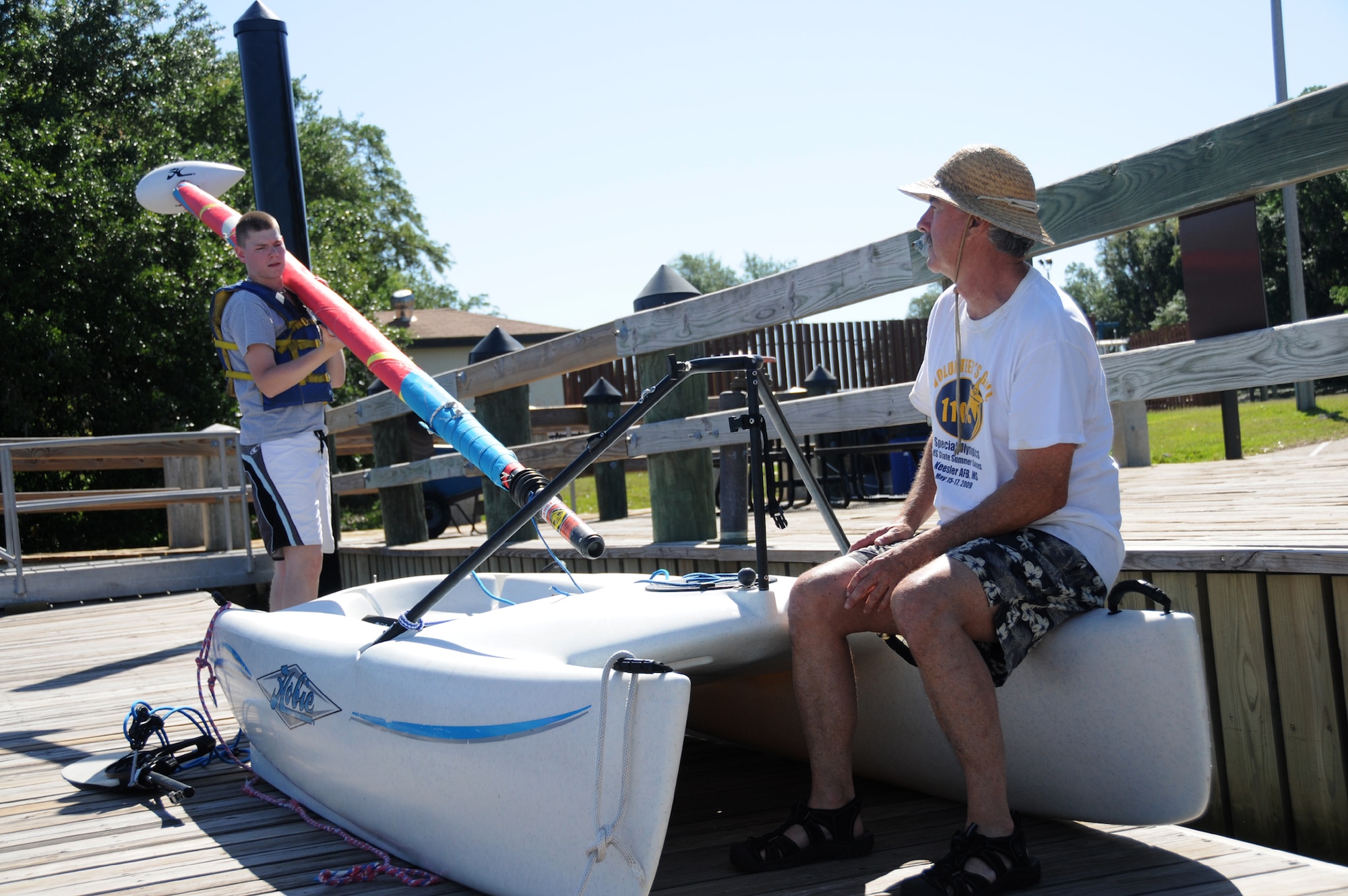 Nathan Rischling, left, 332nd TRS student, learns how to remove a sail and other boating basics before entering the water April 29 as part of a sailing class offered by outdoor recreation at the marina.  For more information, call 377-3160. (U.S. Air Force photo by Kemberly Groue)