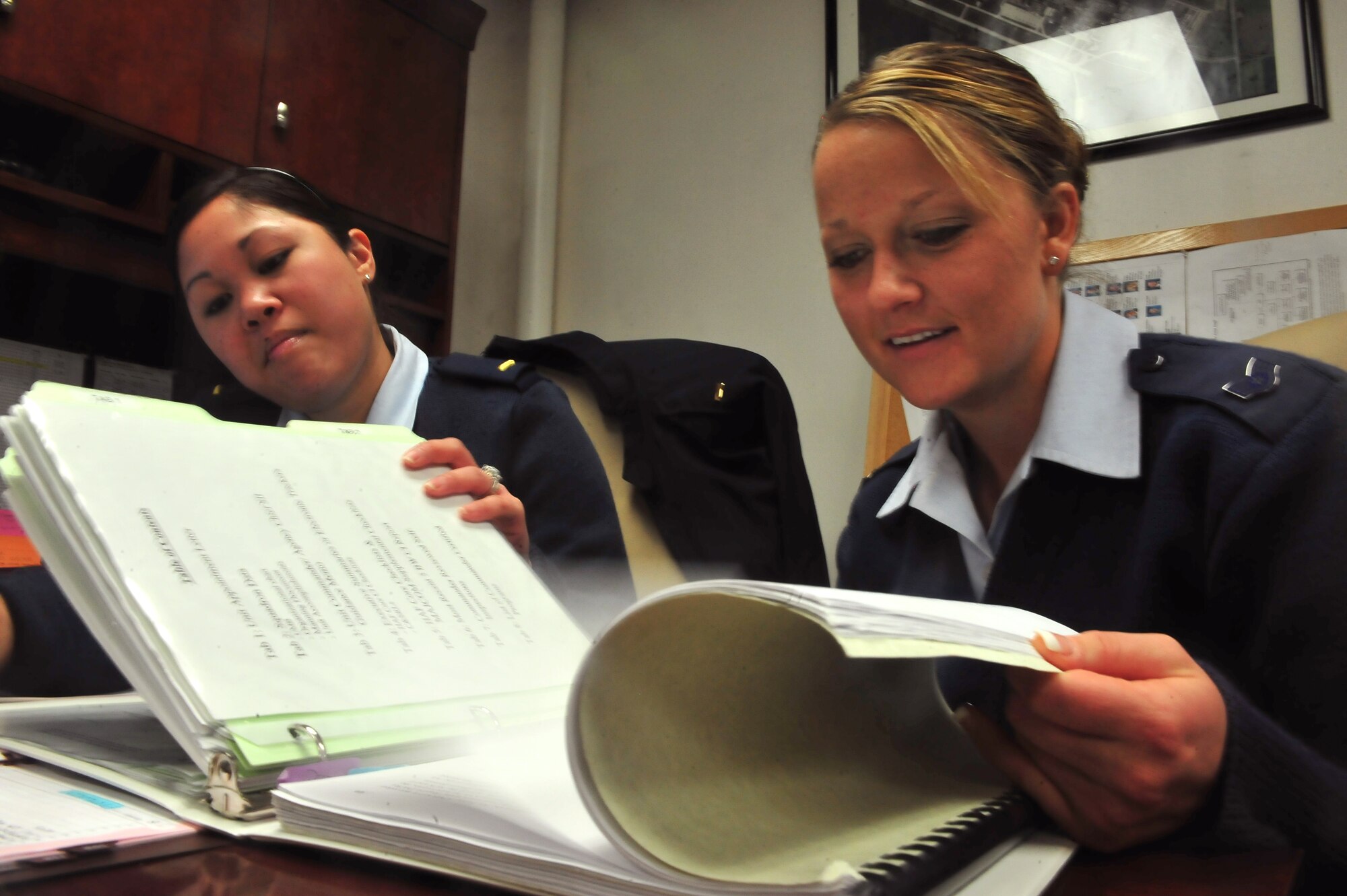 MINOT AIR FORCE BASE -- 2nd Lieutenant Sandra Lee, 5th Force Support Squadron, customer support chief and Staff Sgt. Bridget Bollinger, 5th Bomb Wing protocol personnel, reviews the distinguished visitors’ continuity binder. Protocol personnel are part of a selective, volunteer special duty, assigned to directly support the base commander and vice commander in handling all aspects of distinguished visitor visits, conferences, tours, and social functions initiated within the command. (U.S. Air Force photo/Senior Airman Jesse Lopez)