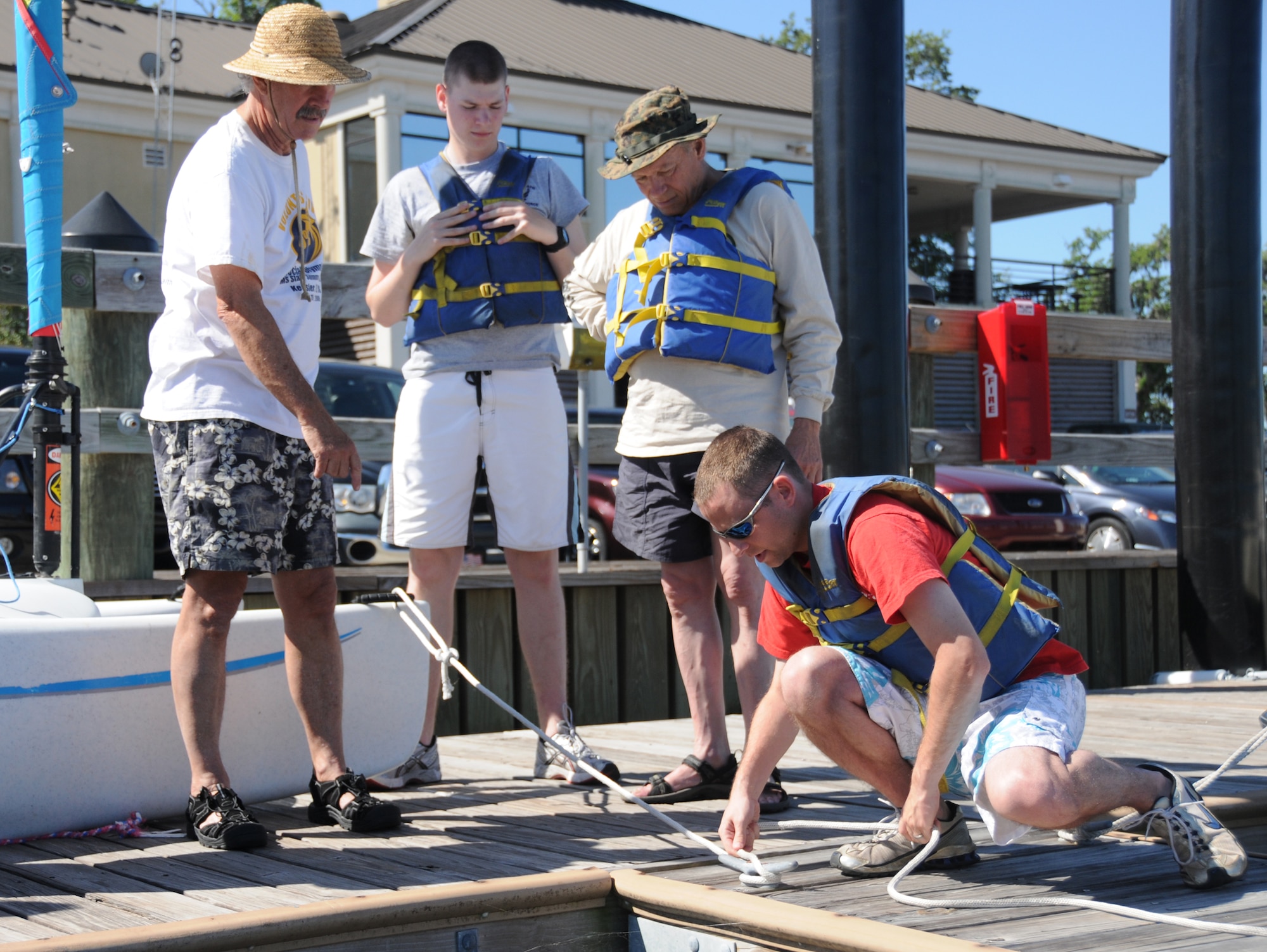 From left, sailing instructor Steve Collins explains to Nathan Rischling, Lou Madden and Mike Quashne the correct way to tie off a sailboat when docking. Rischling is a student in the 332nd Training Squadron, Madden is a retired Soldier and Quashne is assigned to the 335th TRS. The next class includes classroom instruction May 12 and on-the-water training May 13-14 at the marina. For more information, call 377-3160.  (U.S. Air Force photo by Kemberly Groue)