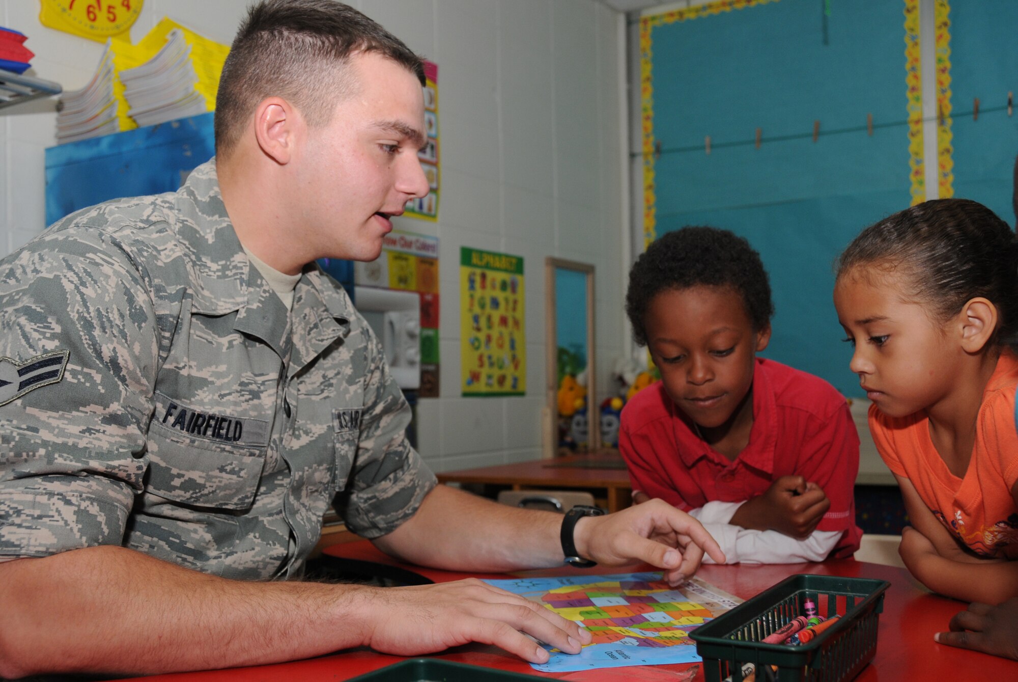 From left, Airman Michael Fairfield, 338th Training Squadron, quizzes 6-year old
kindergarten students Andre Bryant and Aliya Henry on the location of states on the U.S. map Friday at Jeff Davis Elementary School in Biloxi. The children’s mothers are Tech. Sgt. Rickesia Bryant, 336th TRS, and Capt. Jewel Henry, 81st Surgical Operations Squadron. Airman Fairfield was one of the volunteers recruited by the chapel “white rope” student leaders to work with children at the school on non-training
Fridays.  (U.S. Air Force photo by Kemberly Groue)