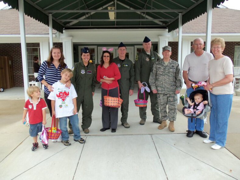 Members of the Kitty Hawk Chapter of the Airlift Tanker Association stand outside The Pines retirement village in late April. Airmen and their families were on-site to spread some holiday cheer to residents. (USAF courtesy photo)