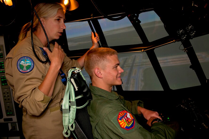MOODY AIR FORCE BASE, Ga.-- U.S. Air Force cadet Joseph Euhus takes the controls of a C-130 simulator as Regina Mizell, 23rd Operation Support Squadron C-130 flight simulator instructor, watches on during an Air Force Academy cadet visit April 29. The cadets had the opportunity to fly in both the C-130 and A-10 simulators. (U.S. Air Force photo/Airman 1st Class Benjamin Wiseman)(RELEASED) 