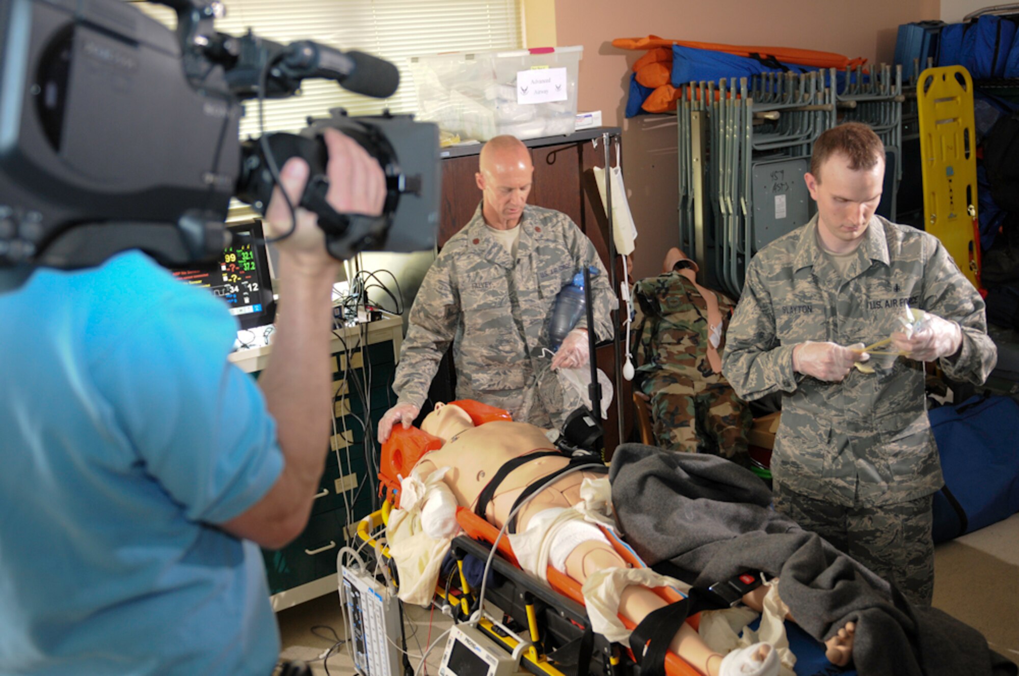 JOINT BASE ANDREWS, Md. -- Maj. Patrick Falvey (left), 459th Aeromedical Staging Squadron critical care nurse, and Tech. Sgt. Joseph Slayton, 459 ASTS medical technician, are filmed by a cameraman from Contrast Creative Apr. 30 here for a media project being organized by Duke University Hospital. In his civilian job, Major Falvey is a Life Flight nurse at the hospital. Some of Duke's patients and employees, including Major Falvey, are being featured in an upcoming film documenting  their inspiring life stories and how they tie into the hospital. (U.S. Air Force photo/Staff Sgt. Sophia Piellusch)