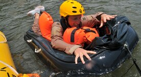 Capt. Amber Jackson, a pilot from the 14th Airlift Squadron at Joint Base Charleston, S.C., boards a one-man life raft during a water survival training course May 2, 2011, at the Charleston Harbor. Each student must use one knee to help boost them up onto the raft. (U.S. Air Force Photo/Airman 1st Class Jared Trimarchi) 