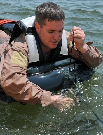 Staff Sgt. Anthony Barrette, Survival Evasion Resistance Escape specialist from the 437th Operations Support Squadron, pulls up an anchor attached to the front of a one-man life raft during a Water Survival Training course May 2, at the Charleston Harbor. During the course each Airman must board the life raft and show the location of the anchor and air valves. (U.S. Air Force photo /Airman 1st Class Jared Trimarchi)
