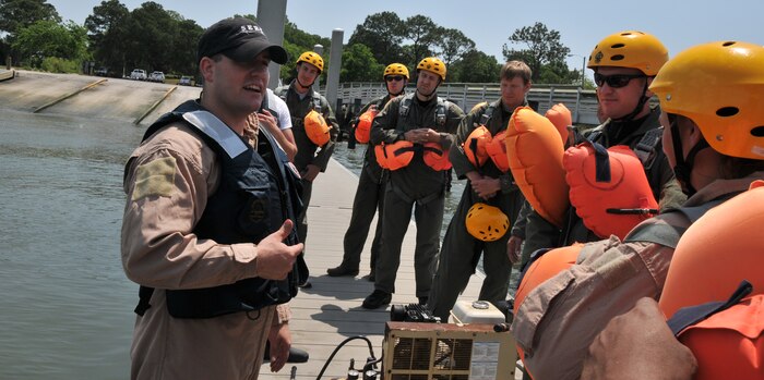 Staff Sgt. Anthony Barrette, Survival Evasion Resistance Escape specialist from the 437th Operations Support Squadron, does a final safety brief before the Airmen board a Zodiac inflatable boat during a Water Survival Training course May 2, at the Charleston Harbor. Each Airmen accomplished three tasks, including being dragged by a parachute, boarding a life raft and coming out from under a parachute. (U.S. Air Force photo /Airman 1st Class Jared Trimarchi)


