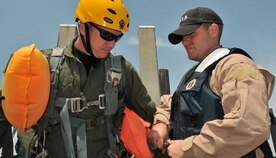 Staff Sgt. Anthony Barrette, a Survival Evasion Resistance Escape specialist from the 437th Operations Support Squadron, inflates the life preserver on one of his students during a Water Survival Training course May 2, 2011, at the Charleston Harbor, S.C. The course is held in the spring and summer months and is designed to teach Airmen how to survive in case of an emergency water landing. (U.S. Air Force Photo/Airman 1st Class Jared Trimarchi)