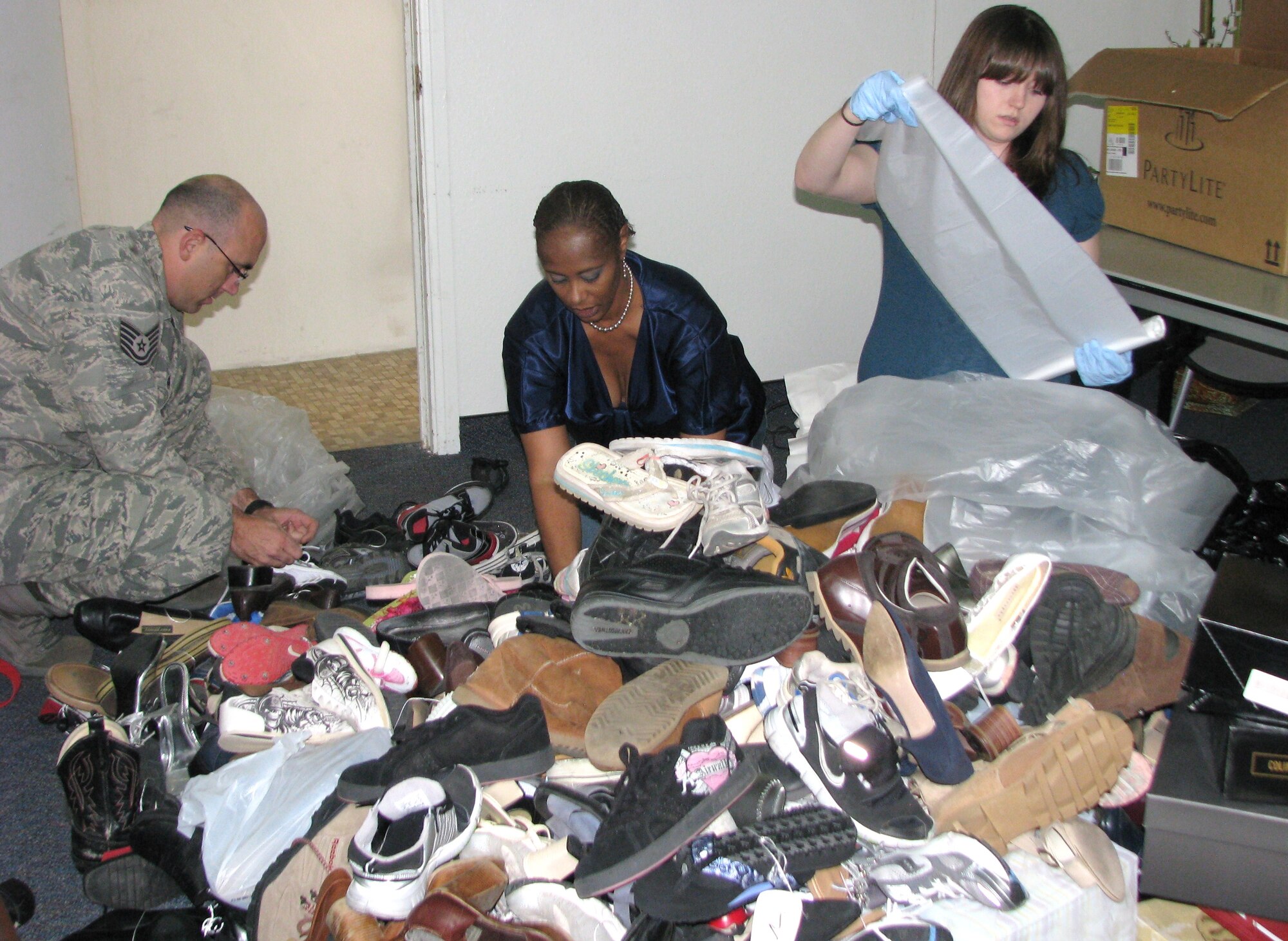 Members of the Sexual Assault Prevention and Response Office sort and package nearly 300 pairs of shoes they collected during the program's second annual shoe drive April 22. The shoes were donated to the Valley Oasis Rape Crisis Center in Lancaster, Calif. Pictured from left are Tech. Sgt. Eric Cullen, 95th Communication Squadron, Kimberly J. Shirley, Sexual Assault Response coordinator and Katyelin Sprague, program assistant. Sergeant Cullen is one of six advocate volunteers with the program. (Air Force photo by Diane Betzler)