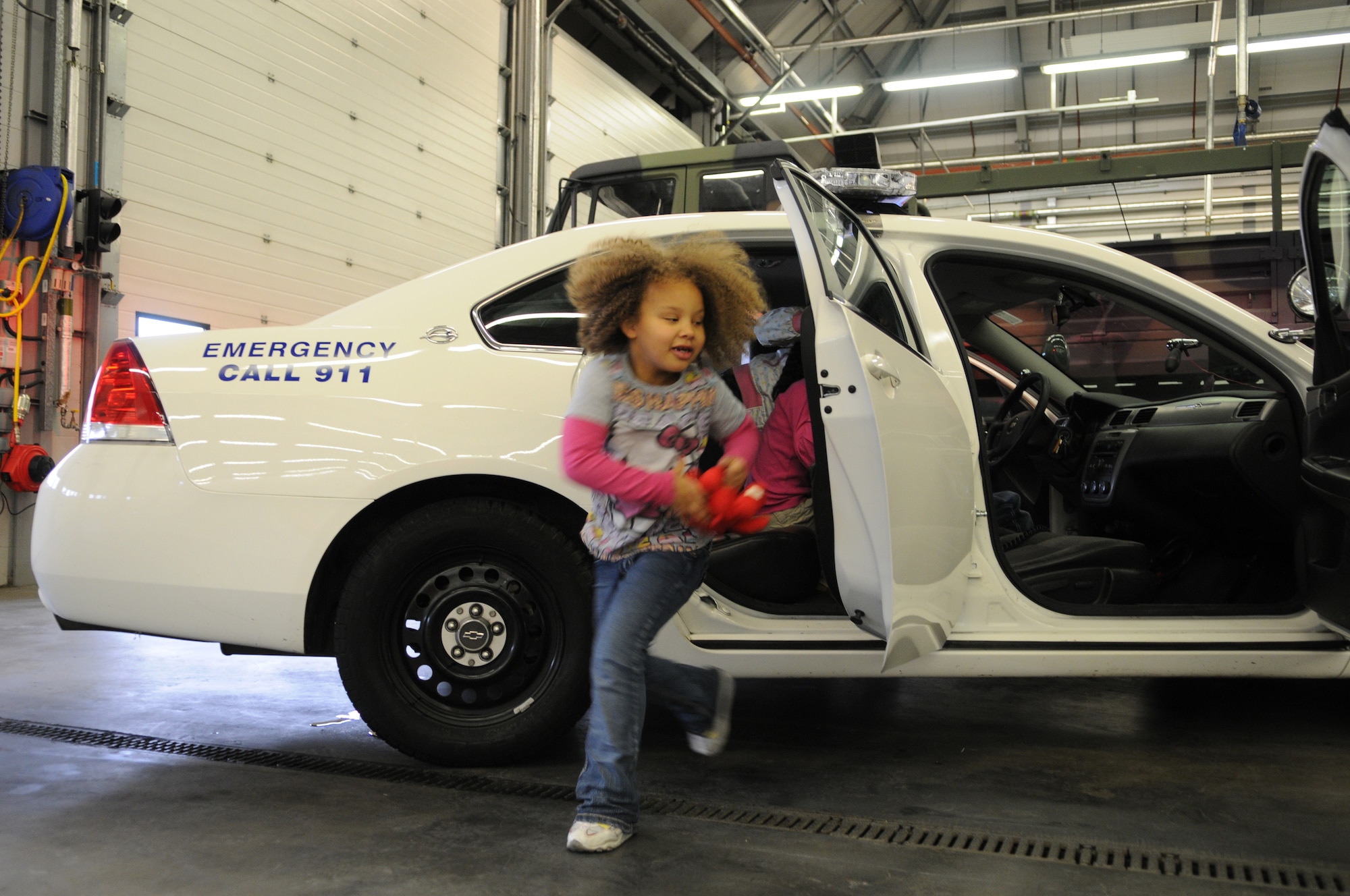 RAF MILDENHALL, England -- Grace Benjamin,6, daughter of Tech. Sgt. Bethany Benjamin, explores a security forces patrol car during RAF Mildenhall's Job Shadow Day here April 28, 2011. This image was taken by a JSD participant as well. The 7-year-old is the son of 100th Air Refueling Wing Public Affairs Staff Sgt. Thomas Trower. (U.S. Air Force photo/Scott Trower)