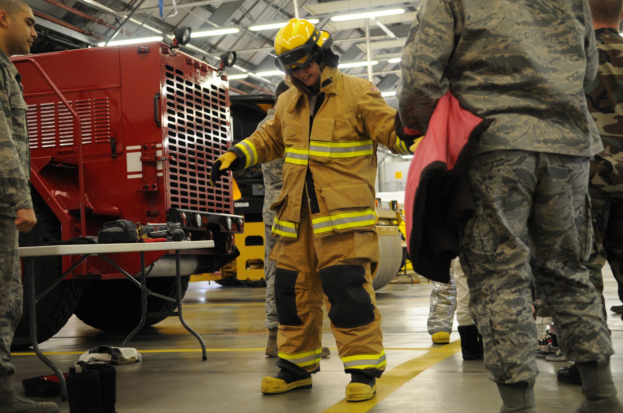 RAF MILDENHALL, England -- Emily Evarts, 11, daughter of Master Sgt. Gordon Evarts, dons a fire protection suit during RAF Mildenhall's Job Shadow Day here April 28, 2011. This image was taken by a JSD participant as well. The 7-year-old is the son of 100th Air Refueling Wing Public Affairs Staff Sgt. Thomas Trower. (U.S. Air Force photo/Scott Trower)