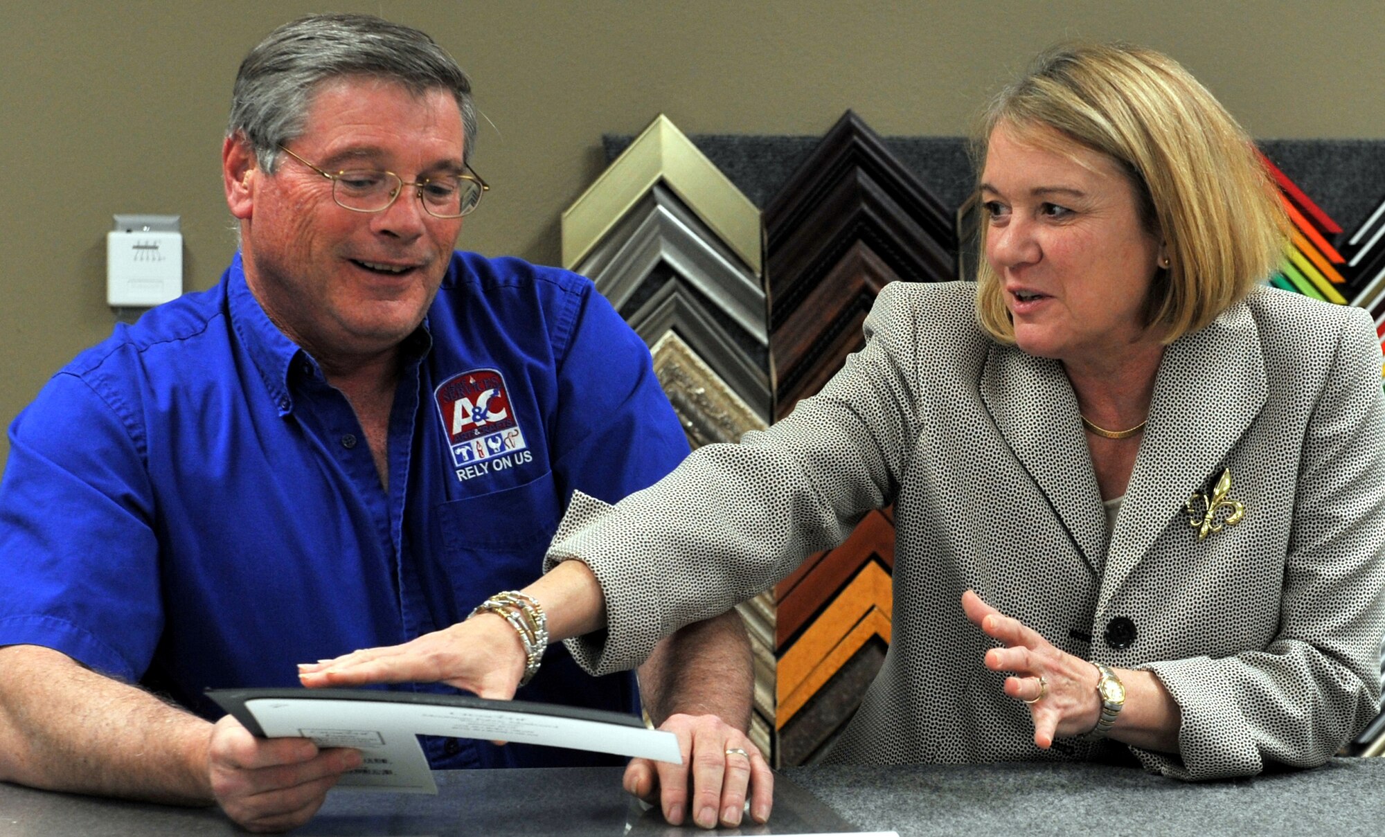 Tom Kiernan, Arts and Crafts director, explains how to prepare a double matt for a custom frame to Julie Kowalski April 25 on a tour of his facility during her orientation tour at Malmstrom. (U.S. Air Force photo/John Turner)