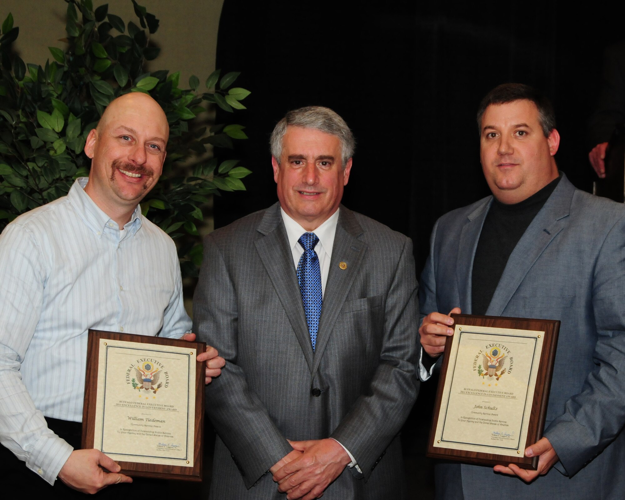 BUFFALO, N.Y.- Mr. William Tiedeman (left), firefighter and Mr. John Schultz (right), fire inspector both from the Niagara Falls Air Reserve Station Fire Department receive the Community Service Award for their efforts in providing meals for the hungry and raising over  $2,000 supporting the Community Missions of Niagara Frontier from William E. Leggiero, Jr., Buffalo Federal Executive Board Chairman . The award ceremony was held at the Buffalo Convention Center.  The 914th Airlift Wing was among many  other federal agencies represented at the ceremony. The wing had seven members win in six different categories. (U.S. Air Force Reserve photo by Peter Borys)
