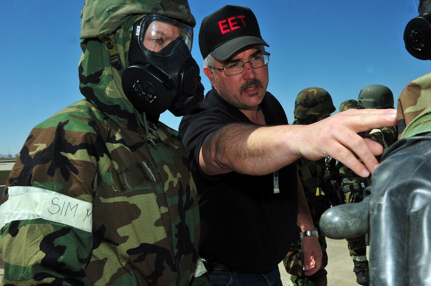 MINOT AIR FORCE BASE, N.D. -- Rodney Onstott, 5th Civil Engineer Squadron, deputy readiness & emergency flight chief, looks on as Airmen 1st Class Sarah Vrachalus, 5th Logistics Readiness Squadron, traffic management apprentice assist a wingman in decontamination training during an Ability to Survive and Operate exercise here May 2. The ATSO preparation exercise ensures that the Airman of Minot ready themselves for upcoming base wide inspections. (U.S. Air Force photo/ Senior Airman Jesse Lopez)